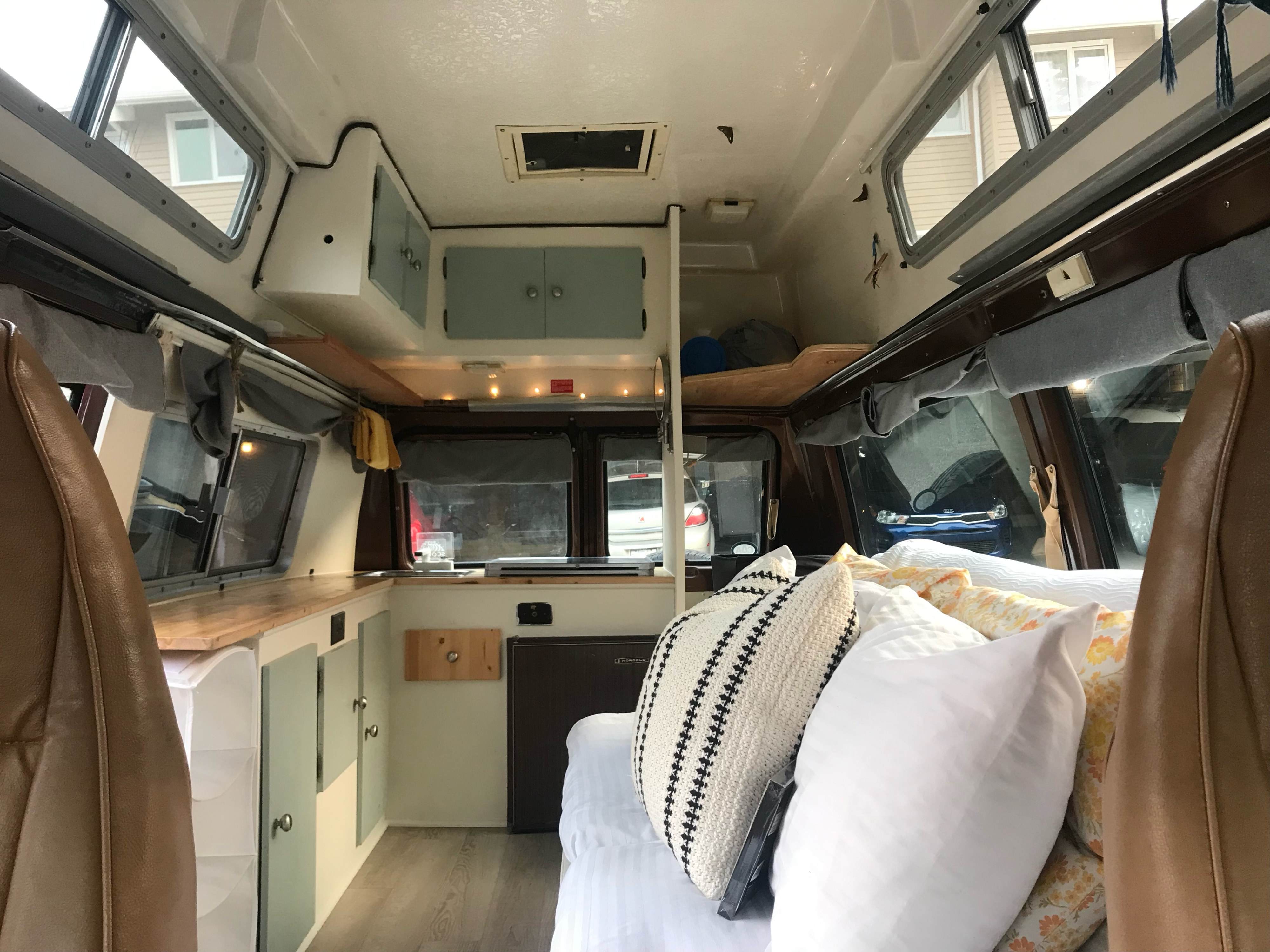 Inside this **RV rental**: a comfy bed, kitchen, storage cabinets, and windows create a cozy mobile living space.. Chevrolet g20 1980