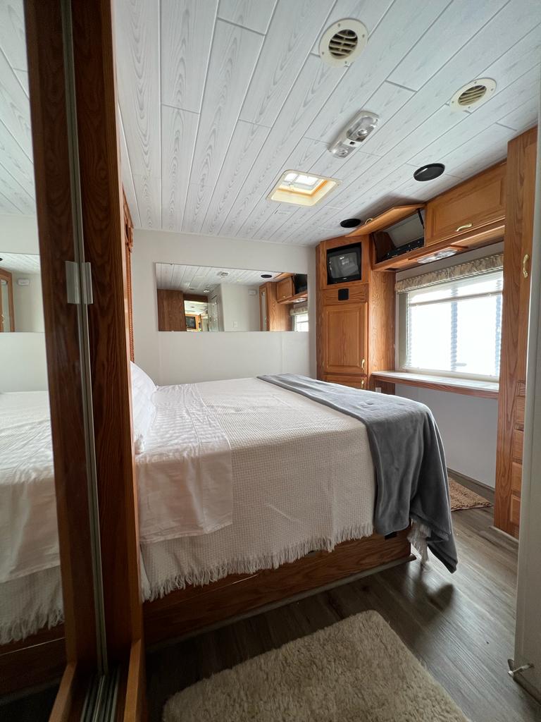 RV rental bedroom: a bright, cozy space with a large bed, wood cabinetry, and modern ceiling features.. Gulf Stream Sun Voyager 2001