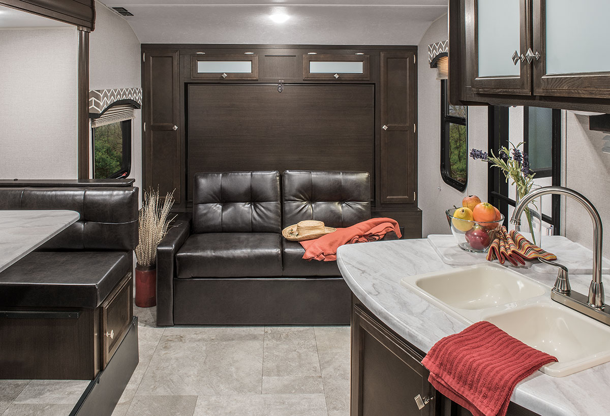 RV rental interior: A compact living space featuring a sofa that converts to a murphy bed, plus a dinette and kitchen.. Sonic Sonic Trailer 2018