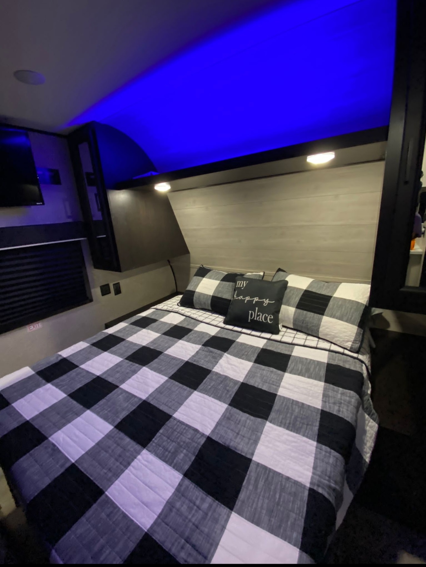 Cozy RV rental bedroom featuring a black and white checkered bed, "my happy place" pillow, and ambient blue lighting.. Jayco 267 BHS 2022