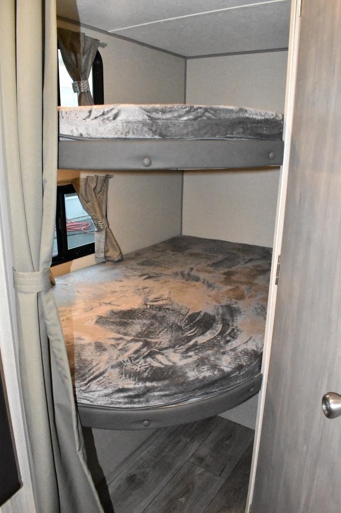 Cozy bunk beds in an RV rental, featuring soft gray bedding, perfect for family adventures on the road.. Forest River Coachmen Catalina Summit 2022