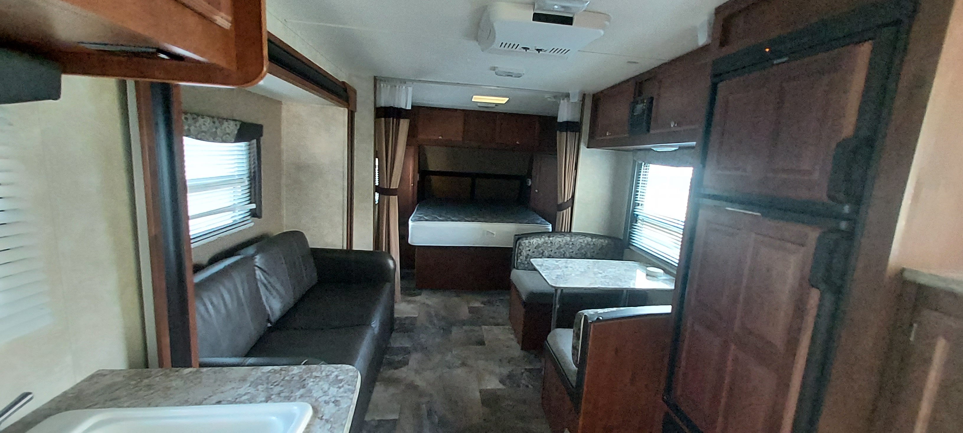 RV rental interior: A cozy living space with a bed, sofa, dinette, and kitchen area, ready for adventure.. Gulf Stream 25TSS 2014