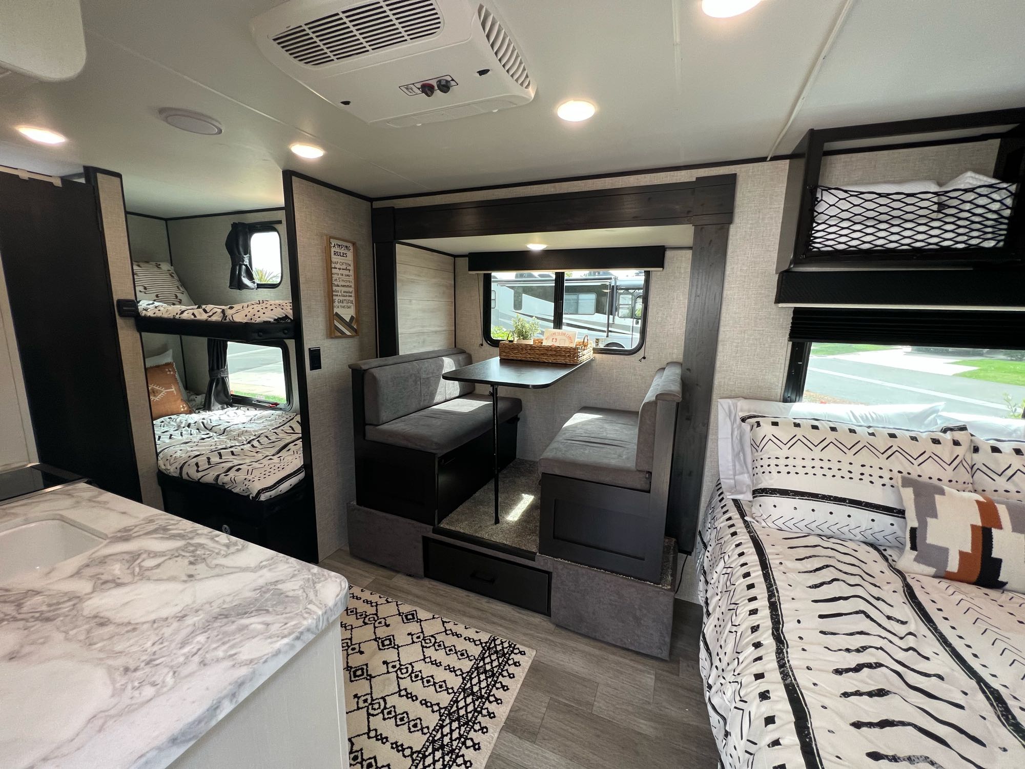 Modern RV rental interior with bunk beds, dinette, and cozy main bed. Perfect travel trailer setup for family adventures.. Jayco Jay Flight 2022
