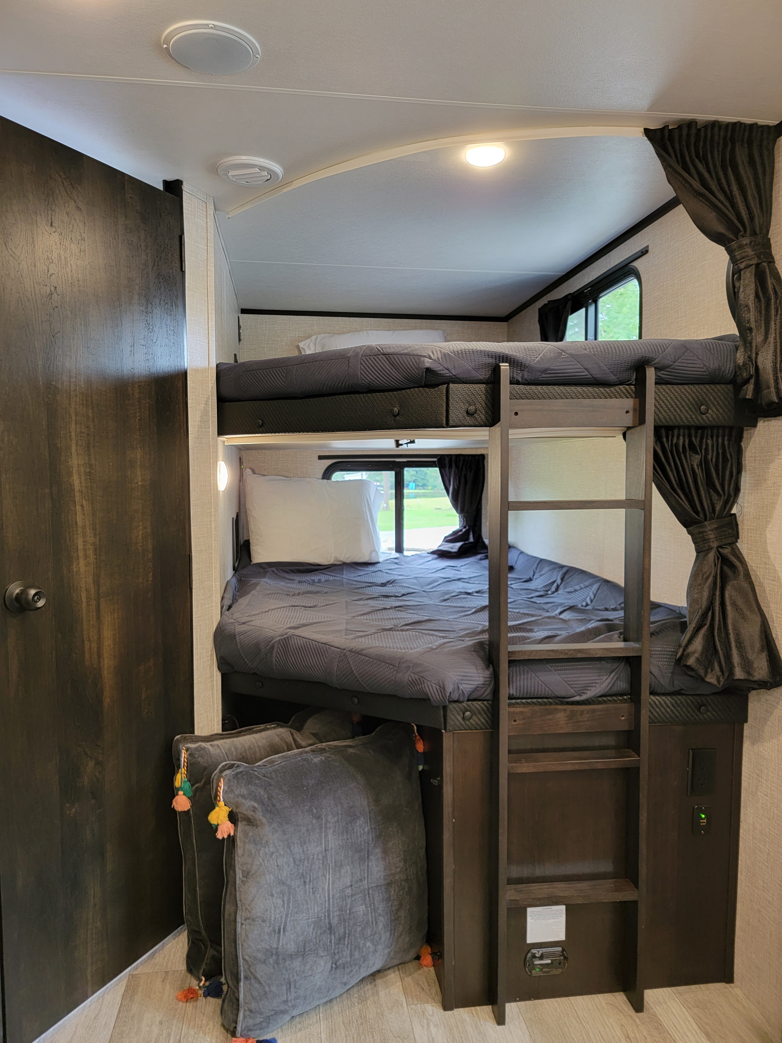 Comfortable RV rental bunk beds with integrated ladder and charging access for convenient travel.. Jayco Jay Feather 2023