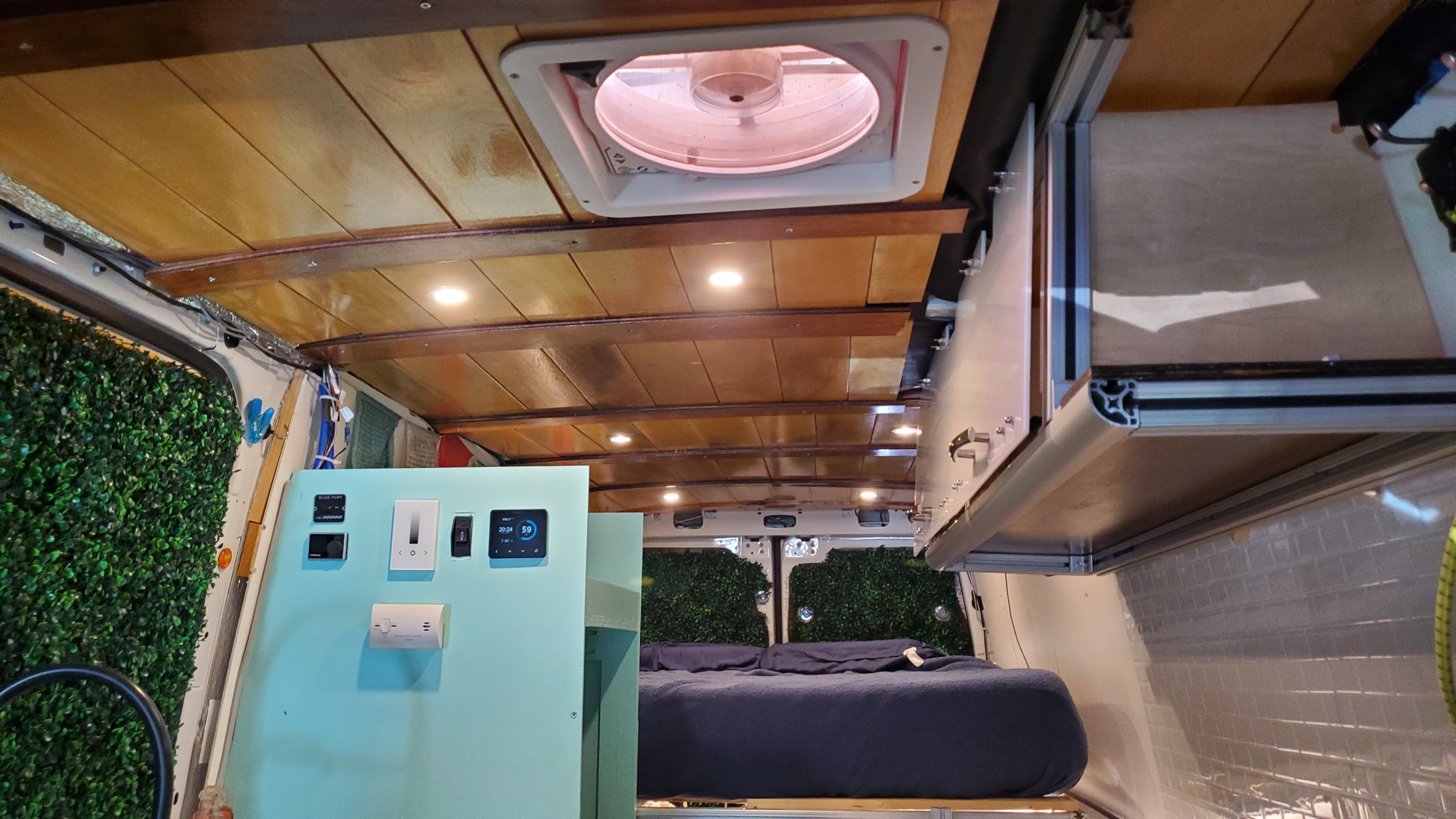 RV rental interior: A cozy bed, custom wood ceiling, and control panel visible in this sleek camper van design.. Mercedes Benz Sprinter 2019