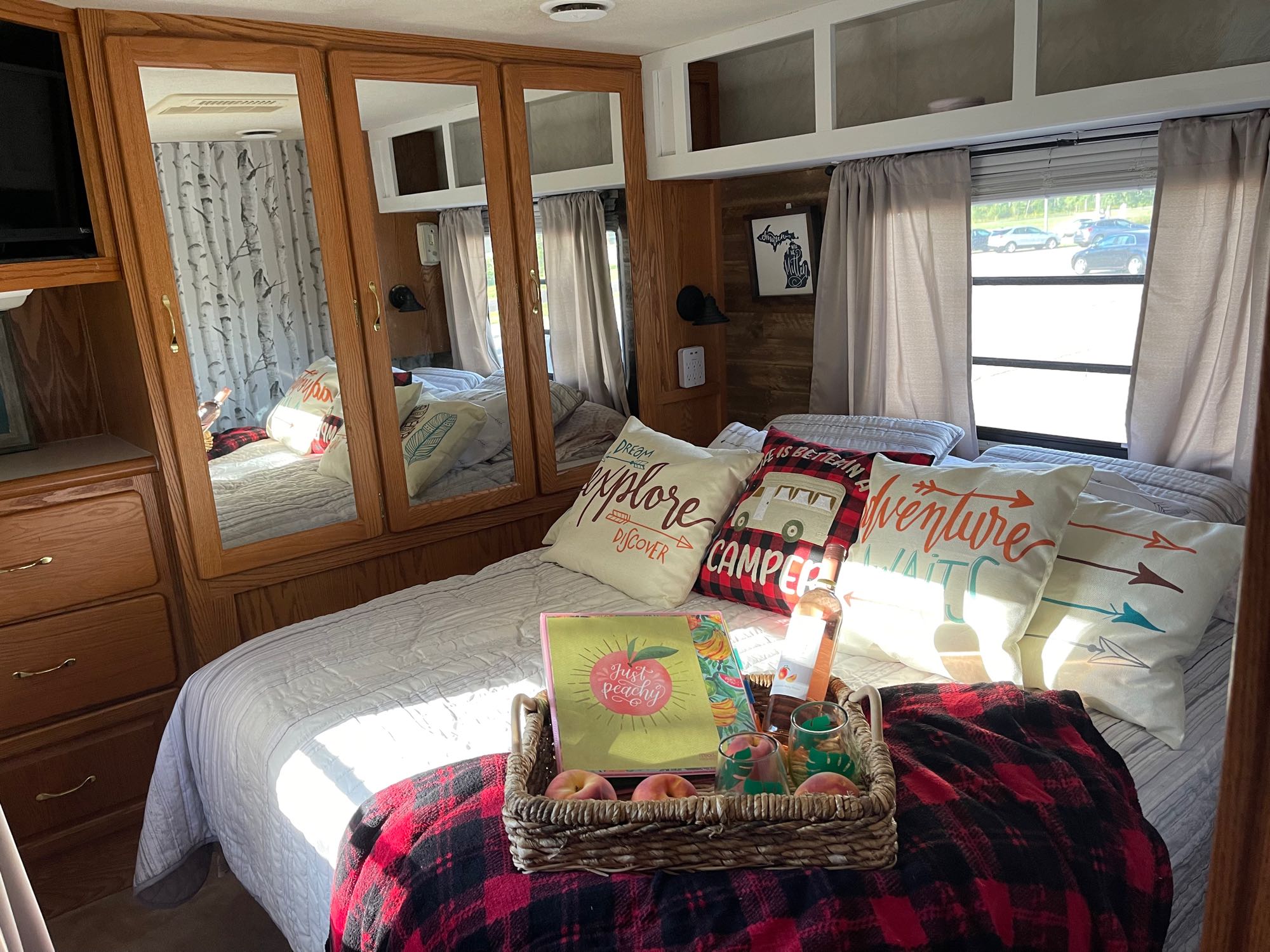 Step into this inviting RV rental bedroom! A comfy bed, peachy treats, and cozy decor make for a perfect getaway.. Georgie Boy Cruise Air 2000