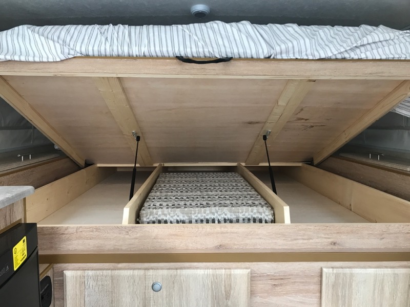 RV rental: Lifted camper bed reveals generous under-bed storage, assisted by gas struts. Maximizes space efficiently.. Northstar Truck Camper Tc650 2021