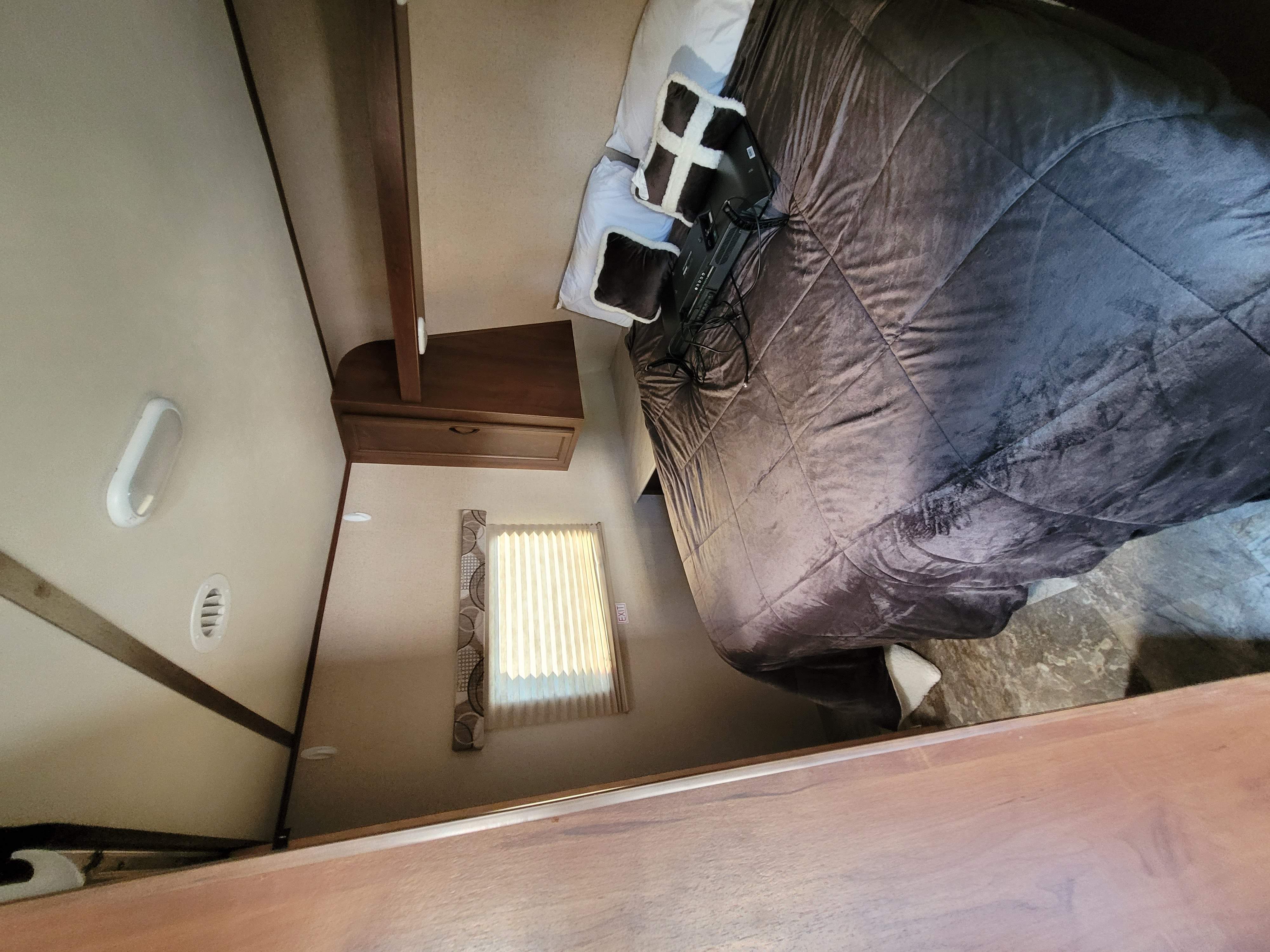 Comfortable RV rental bedroom with large bed, TV, cabinet, and window blinds. Ideal for travel accommodation.. Jayco Jay Feather Ultra Lite SLX 2015