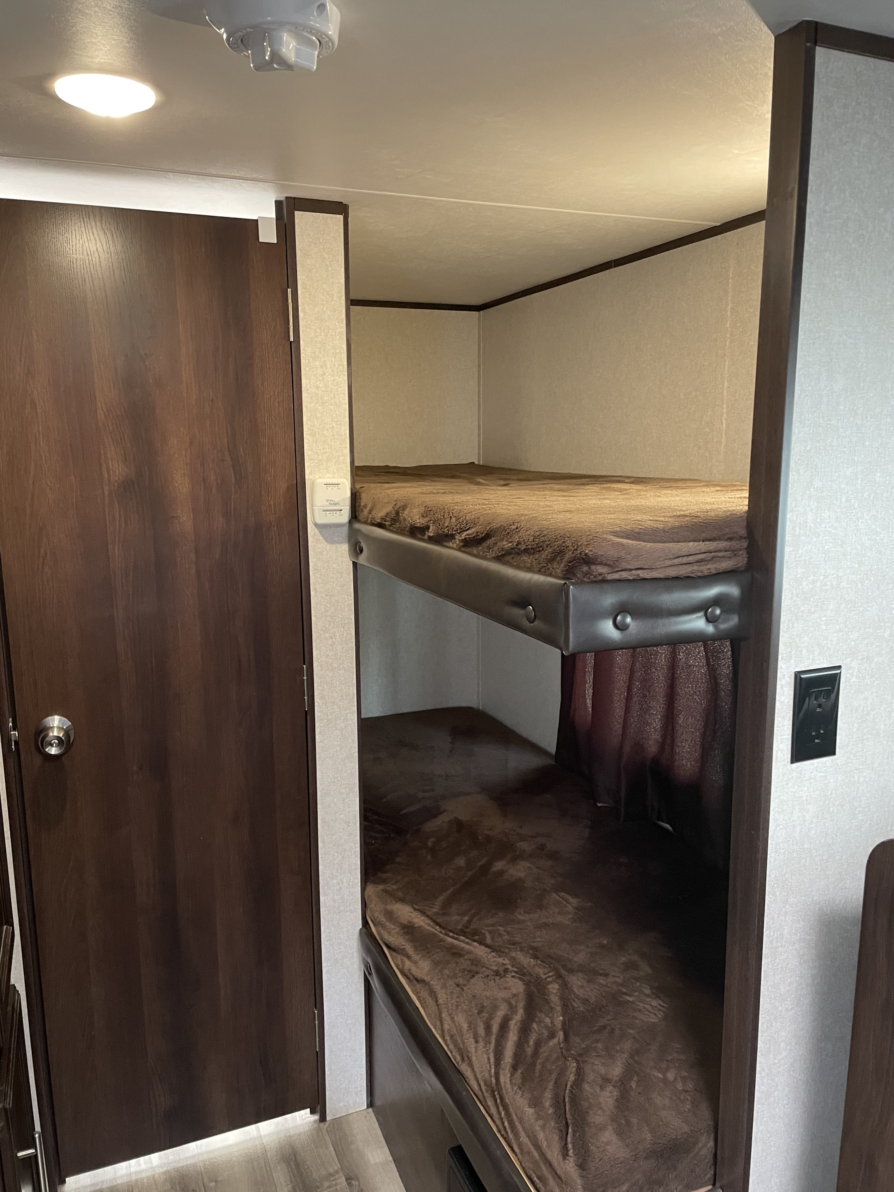 RV rental interior featuring cozy bunk beds with brown blankets, ideal for a comfortable sleeping area in your camper.. Jayco Jay Flight SLX Baja Edition 2019