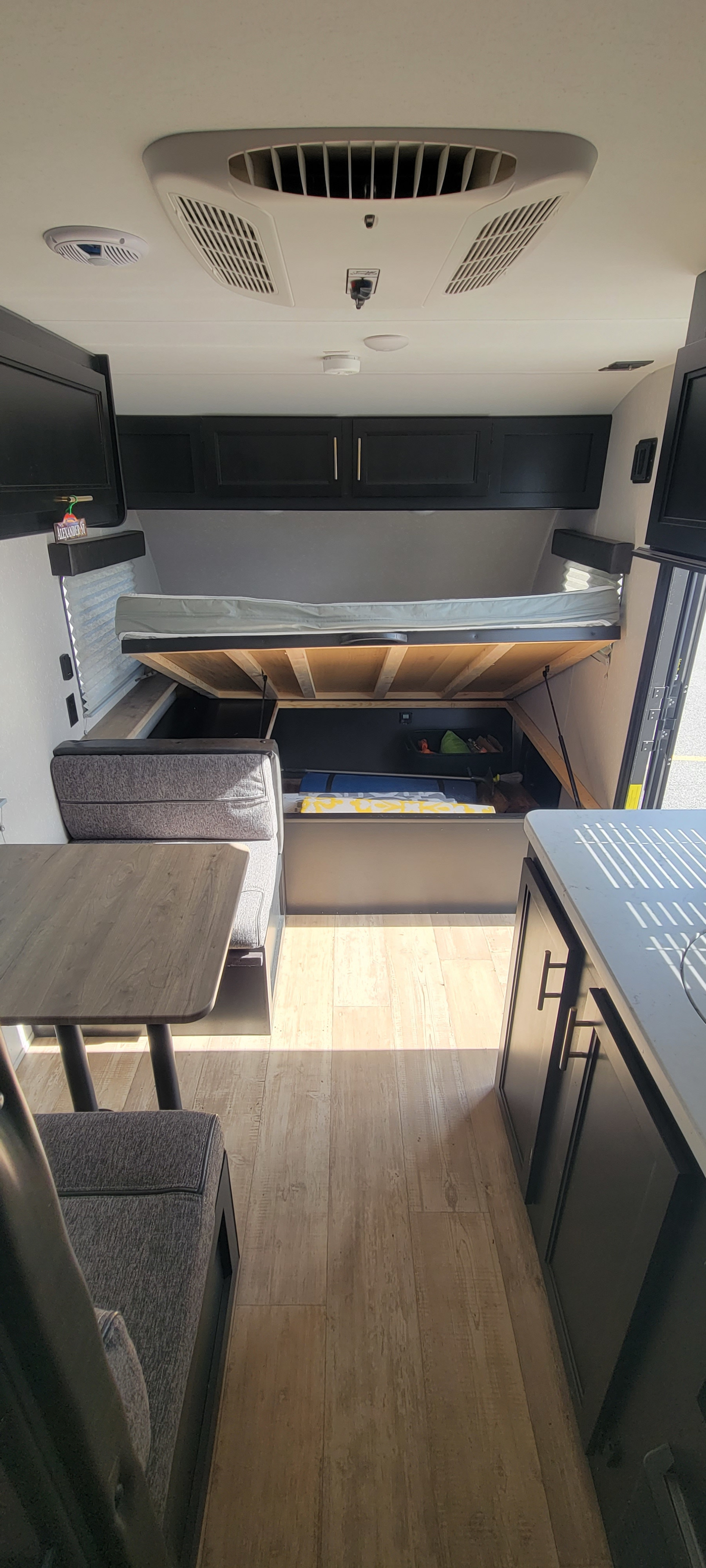 Spacious RV rental interior with lift-up bed for storage, dinette, and kitchen. Perfect for your next adventure!. Forest River Cherokee Wolf Pup 2021