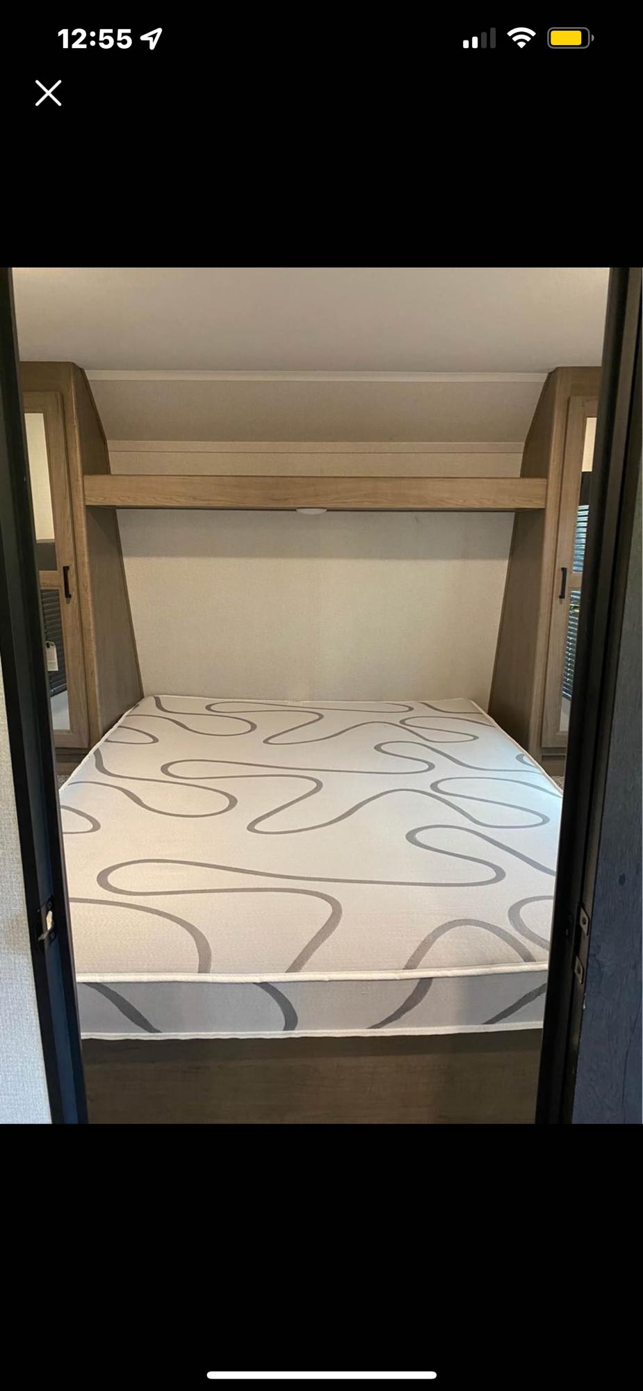 This RV rental offers a comfortable bedroom with a patterned mattress and convenient overhead storage.. Keystone RV Hideout Luxury 2021