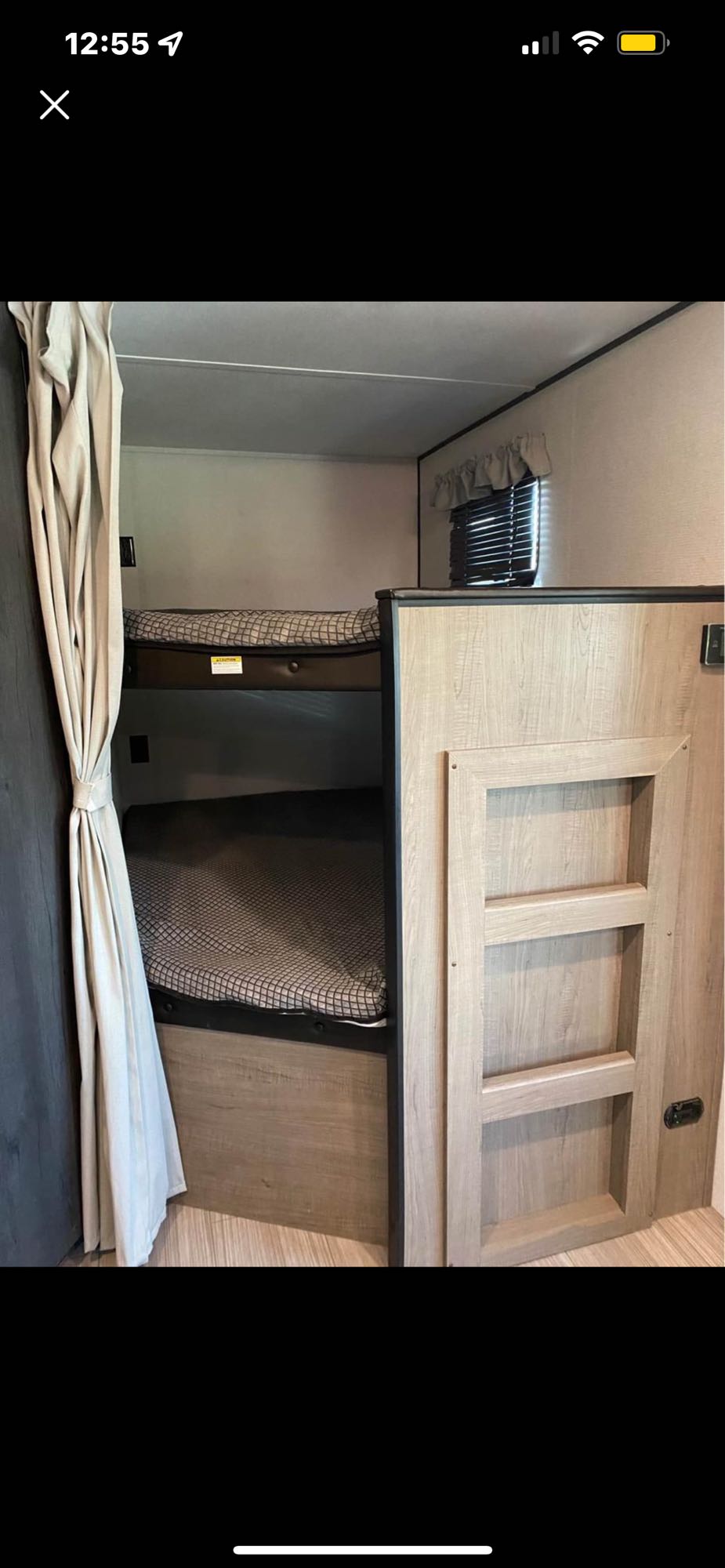 This RV rental offers comfortable bunk beds, a cozy sleeping area with patterned mattresses and a privacy curtain.. Keystone RV Hideout Luxury 2021
