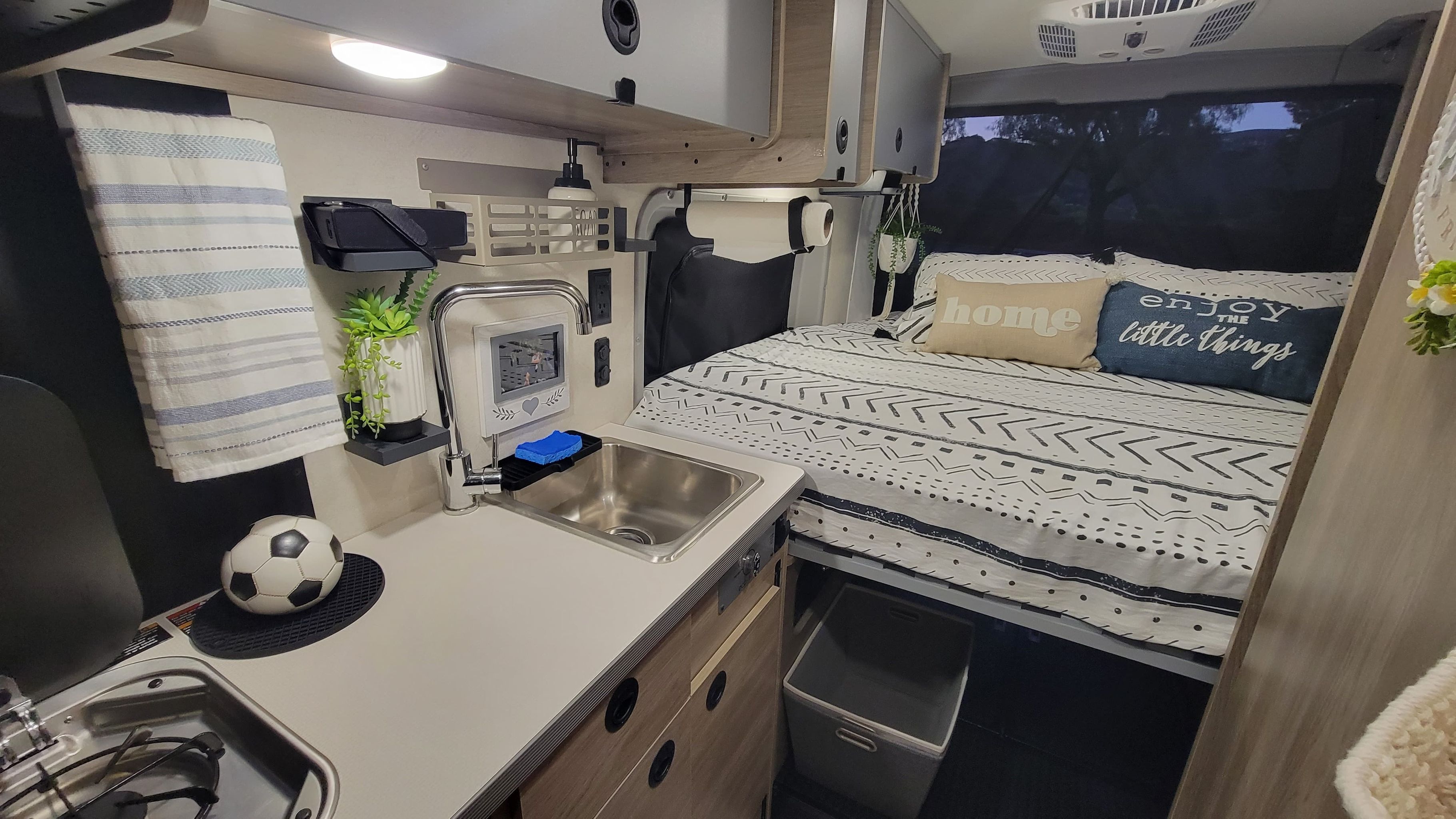 Cozy RV rental interior with compact kitchen & sink next to a comfortable bed for travel.. Winnebago Winnebago 2023