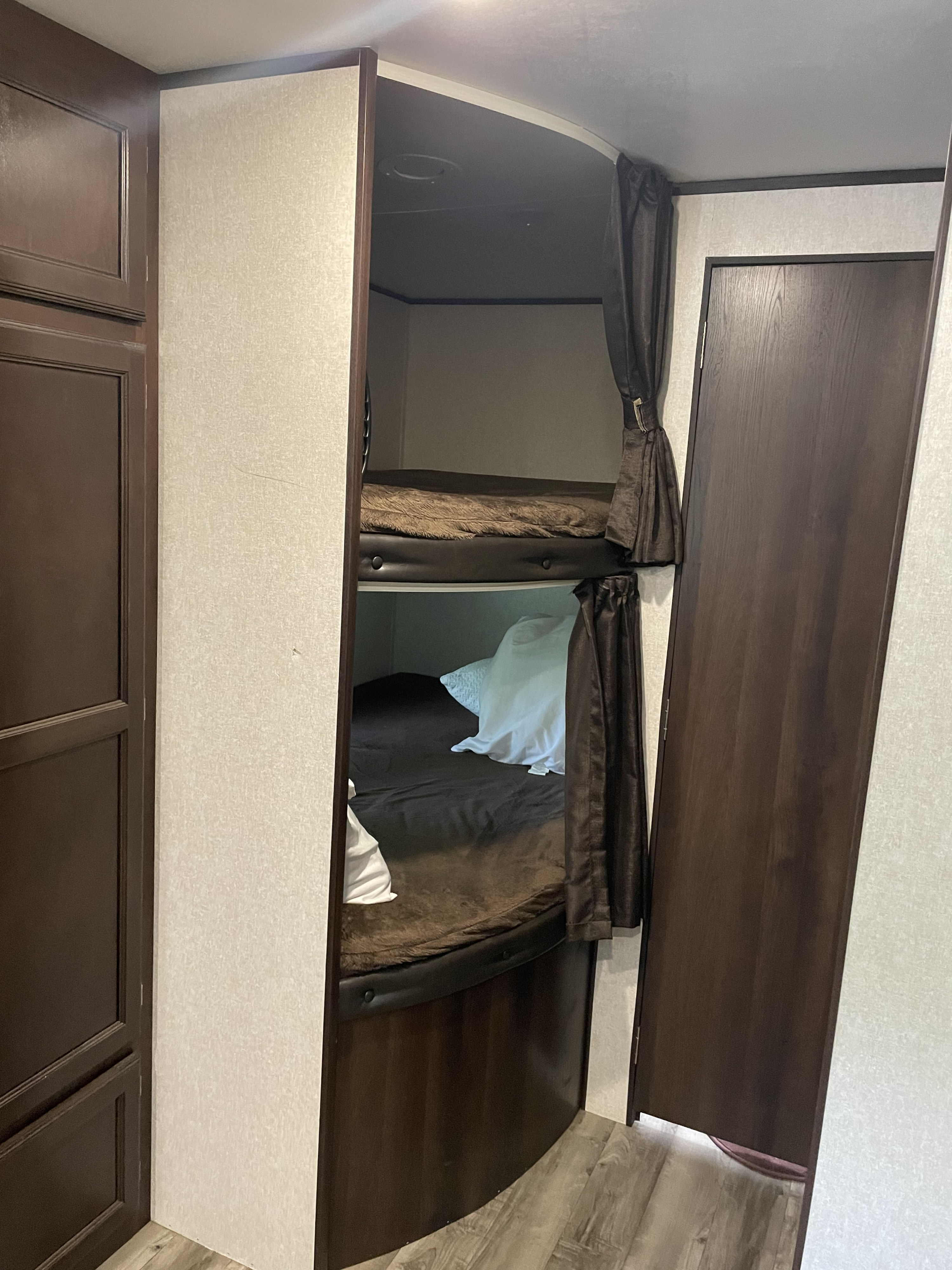 Cozy bunk beds with privacy curtains inside an RV rental. Ideal for family adventures.. Jayco Jay Flight SLX Rocky Mtn Edition 2019