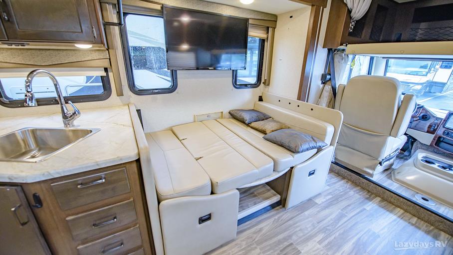 RV rental interior featuring a compact kitchen, convertible dinette bed, and TV, designed for comfortable travel.. Thor A.C.E. 2020