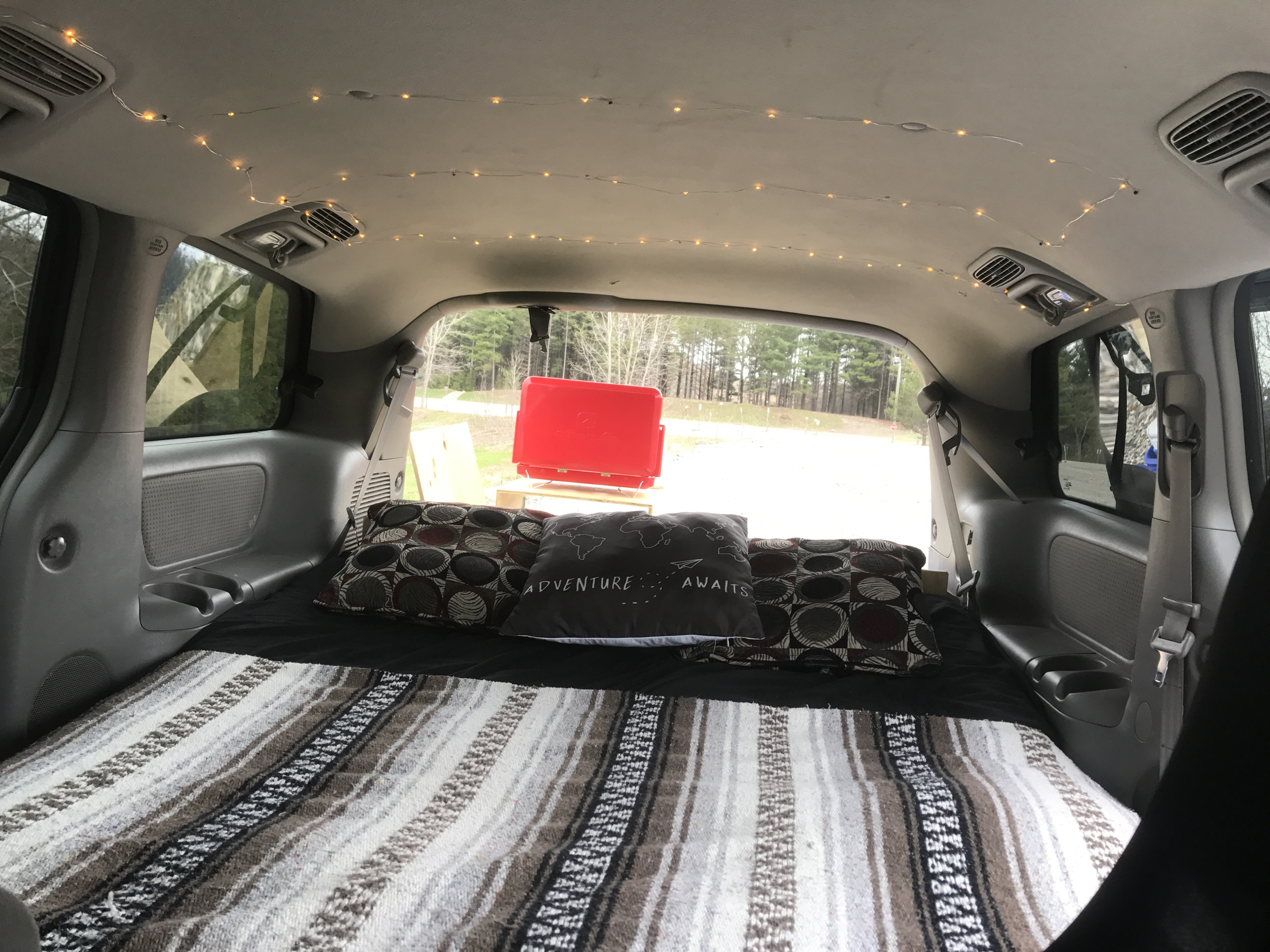 Cozy RV rental interior: a converted vehicle with bed, blanket, string lights, ready for adventure.. Toyota Sienna 2010