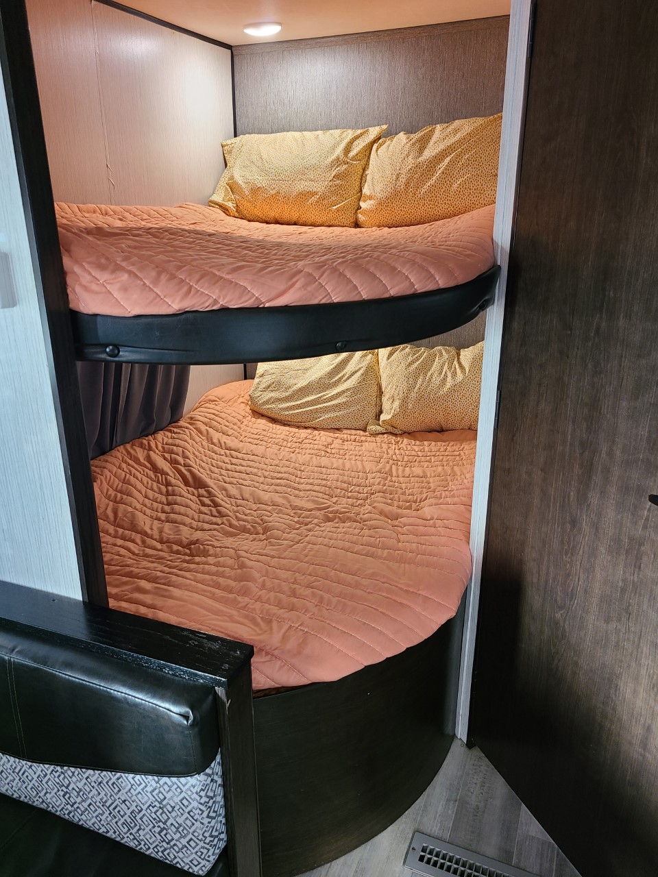 RV rental bunk beds with orange bedding, providing comfortable sleeping arrangements for family travel.. Heartland Prowler 2020