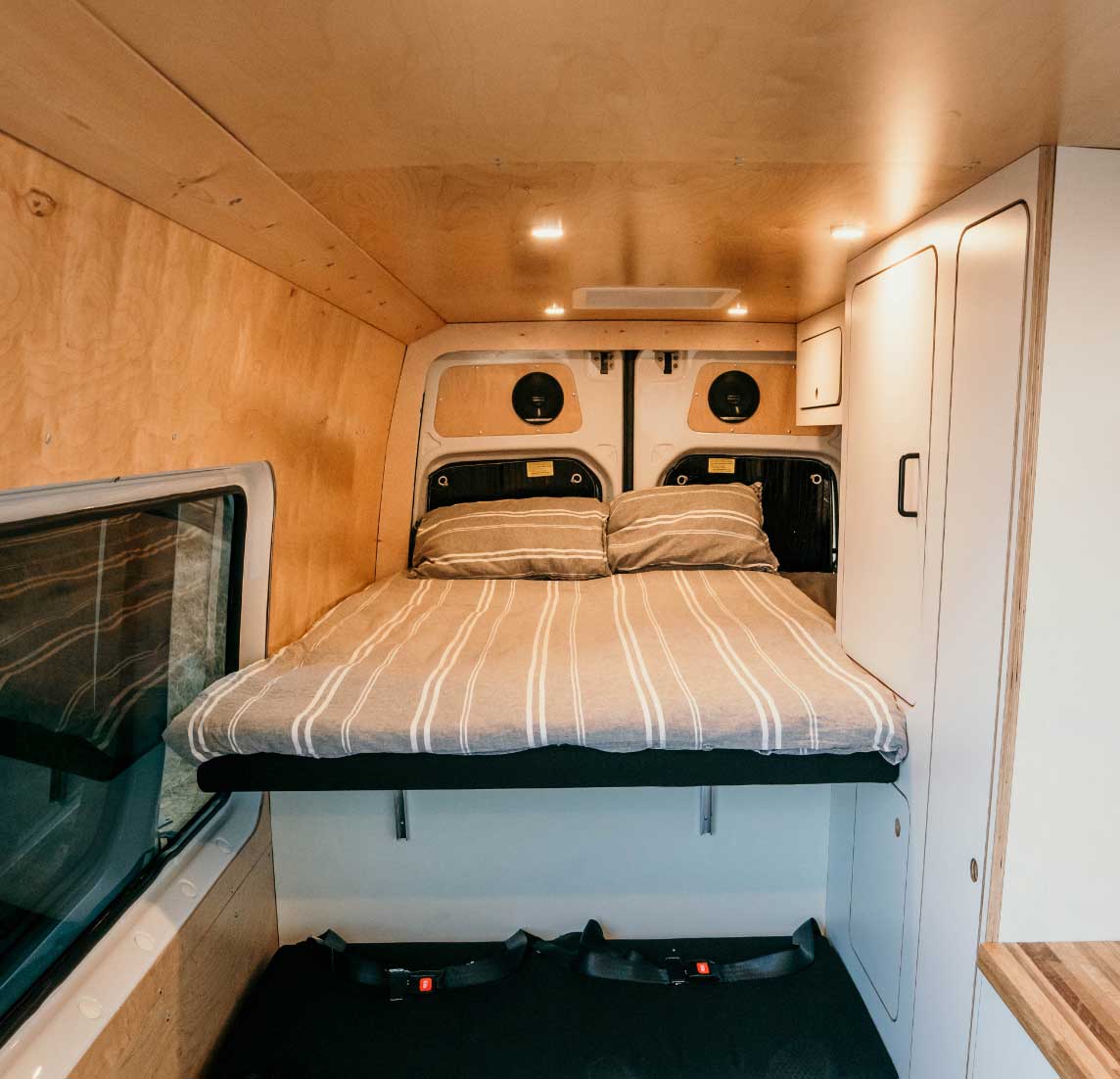Cozy RV rental interior with wood-paneled walls, a comfortable bunk bed, & cabinets. Ready for your next adventure.. Mercedes-Benz Sprinter 2022