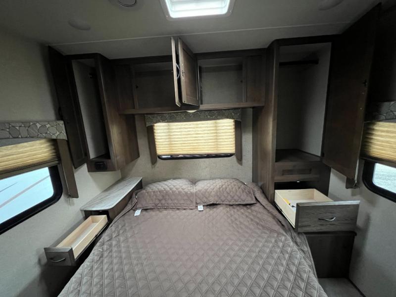 RV rental bedroom with cozy bed, open overhead cabinets, and pull-out drawers for your travel needs.. Coachmen Freelander 2019