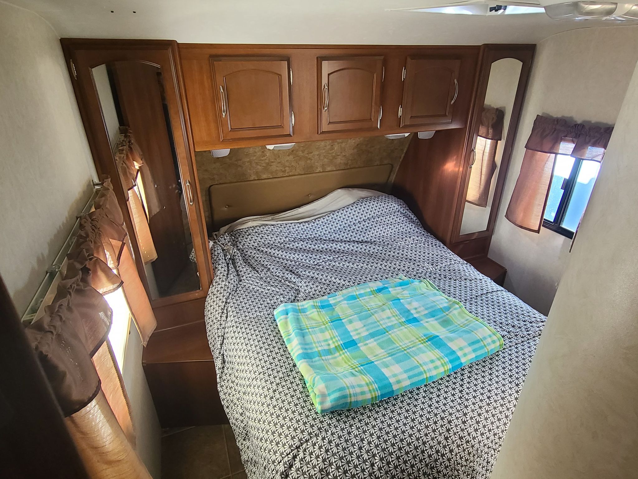 Compact rv rental bedroom with a cozy bed, ample storage, and bedside windows.. Forest River Coachmen Freedom Express 2014