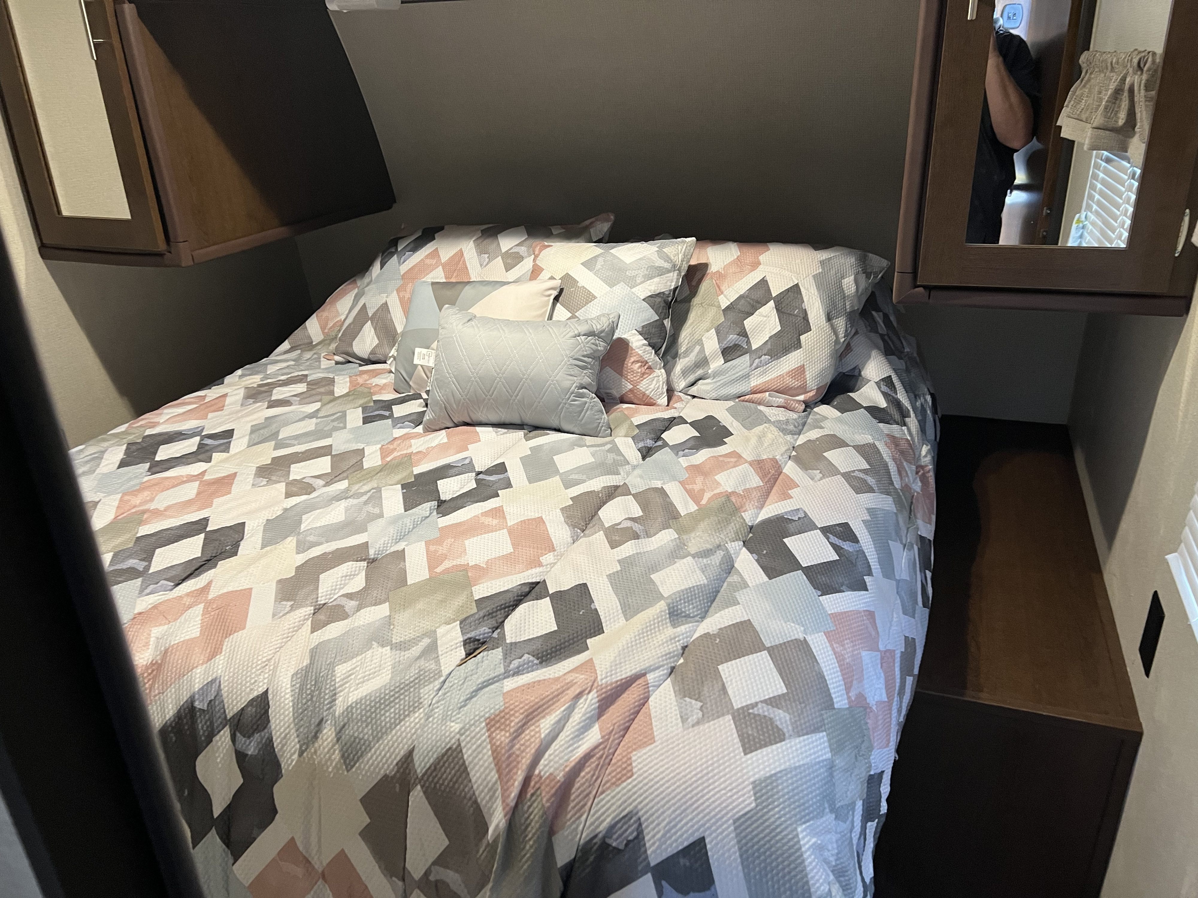 Cozy RV rental bedroom featuring a bed with a modern geometric comforter and cabinet storage.. Avenger 31DBS 2019