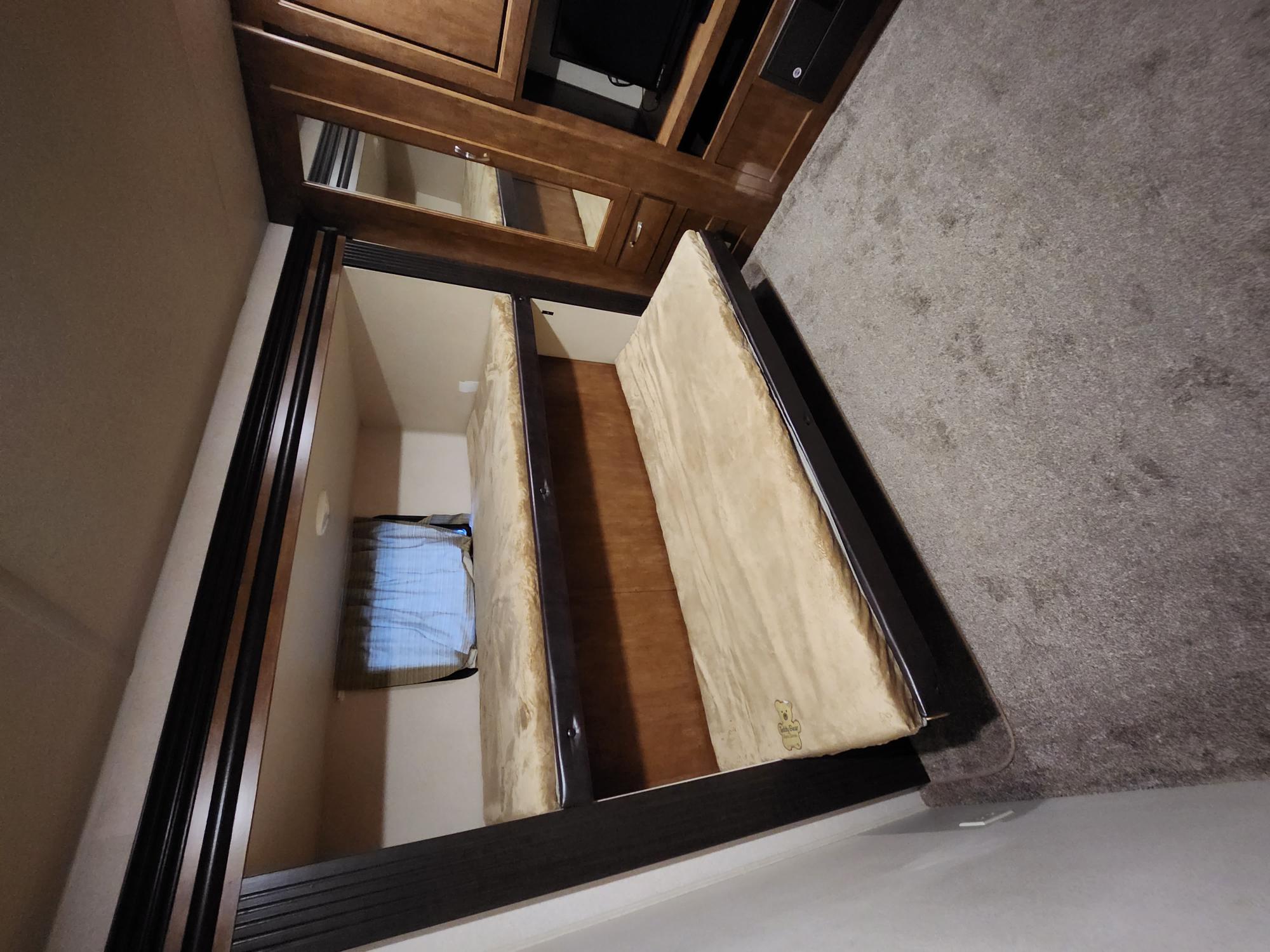 Inside this RV rental, discover a functional sleeping space featuring two bunk beds, a window, and built-in wood cabinets.. Forest River Wildwood 2017