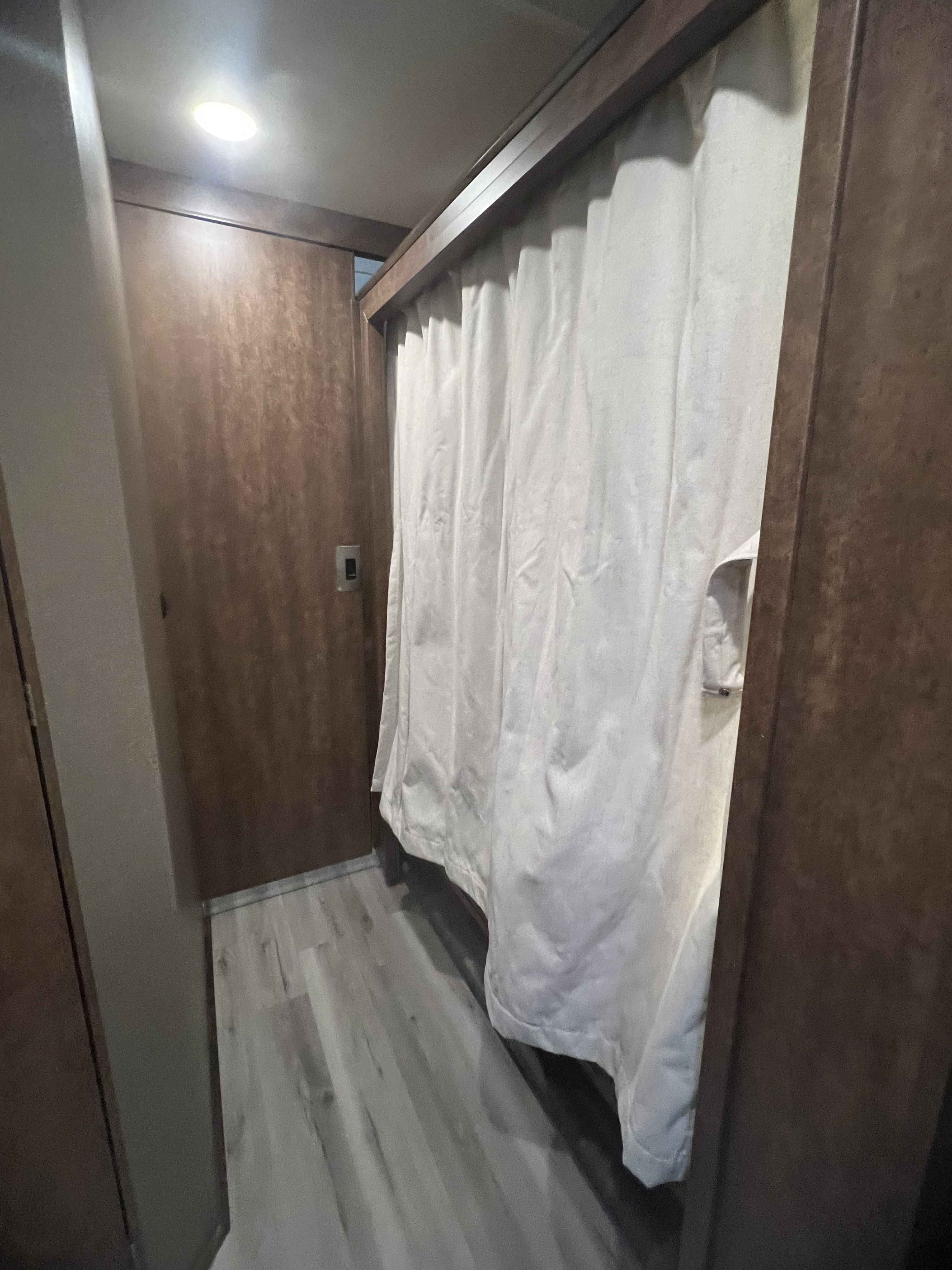 RV rental interior: A bright, narrow hallway with wood-look walls, light flooring, and a white privacy curtain for a private zone.. Winnebago Other 2018