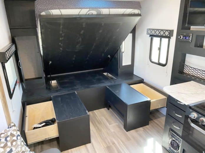Explore this RV rental's versatile interior: a lift-up bed maximizes space with storage drawers and a compact kitchen.. Forest River Coachmen Freedom Express Ultra Lite 2022