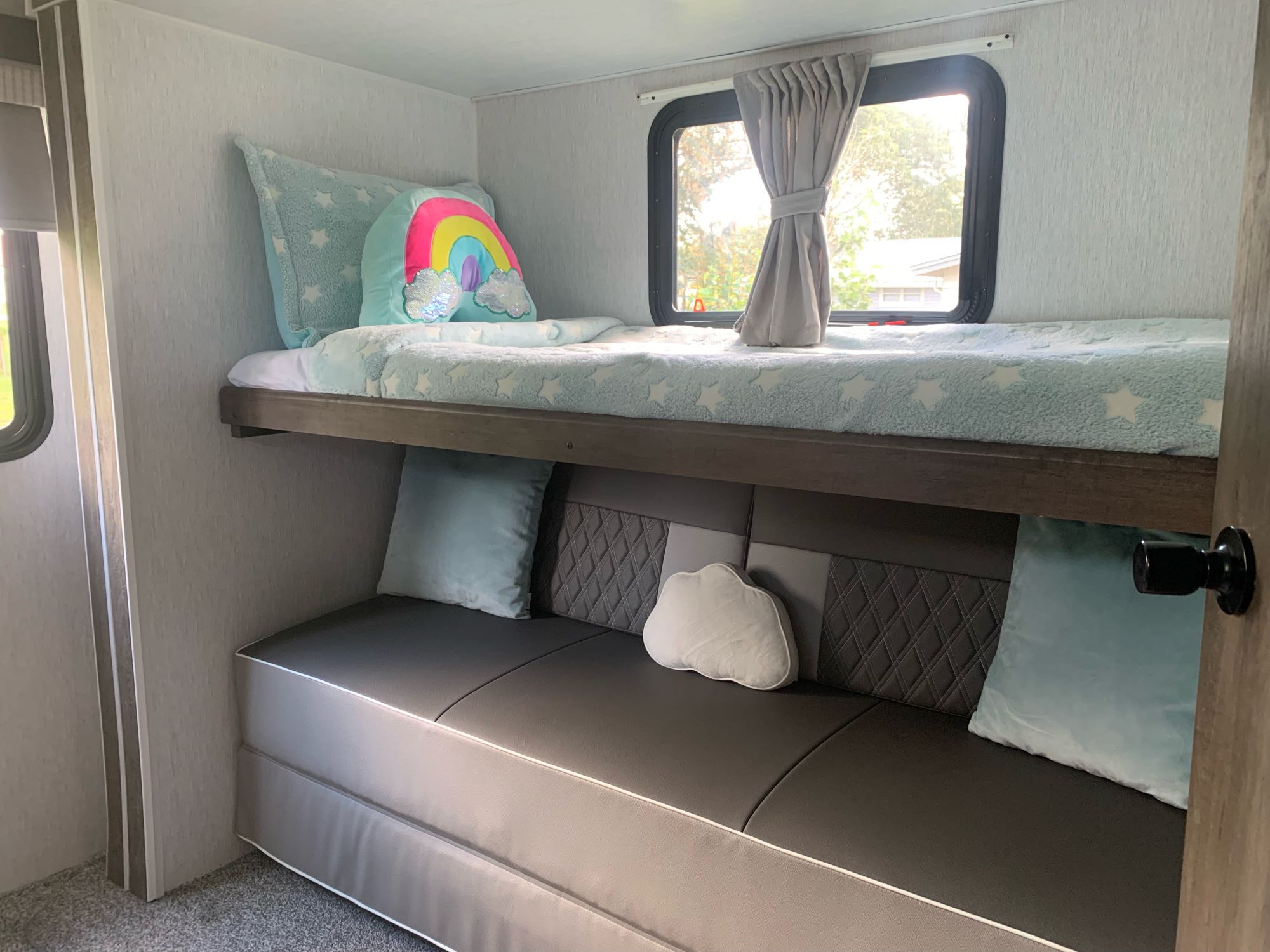 RV rental bunk beds and plush seating area. Featuring a rainbow pillow & starry blanket, perfect for cozy comfort.. Forest River Salem 2022