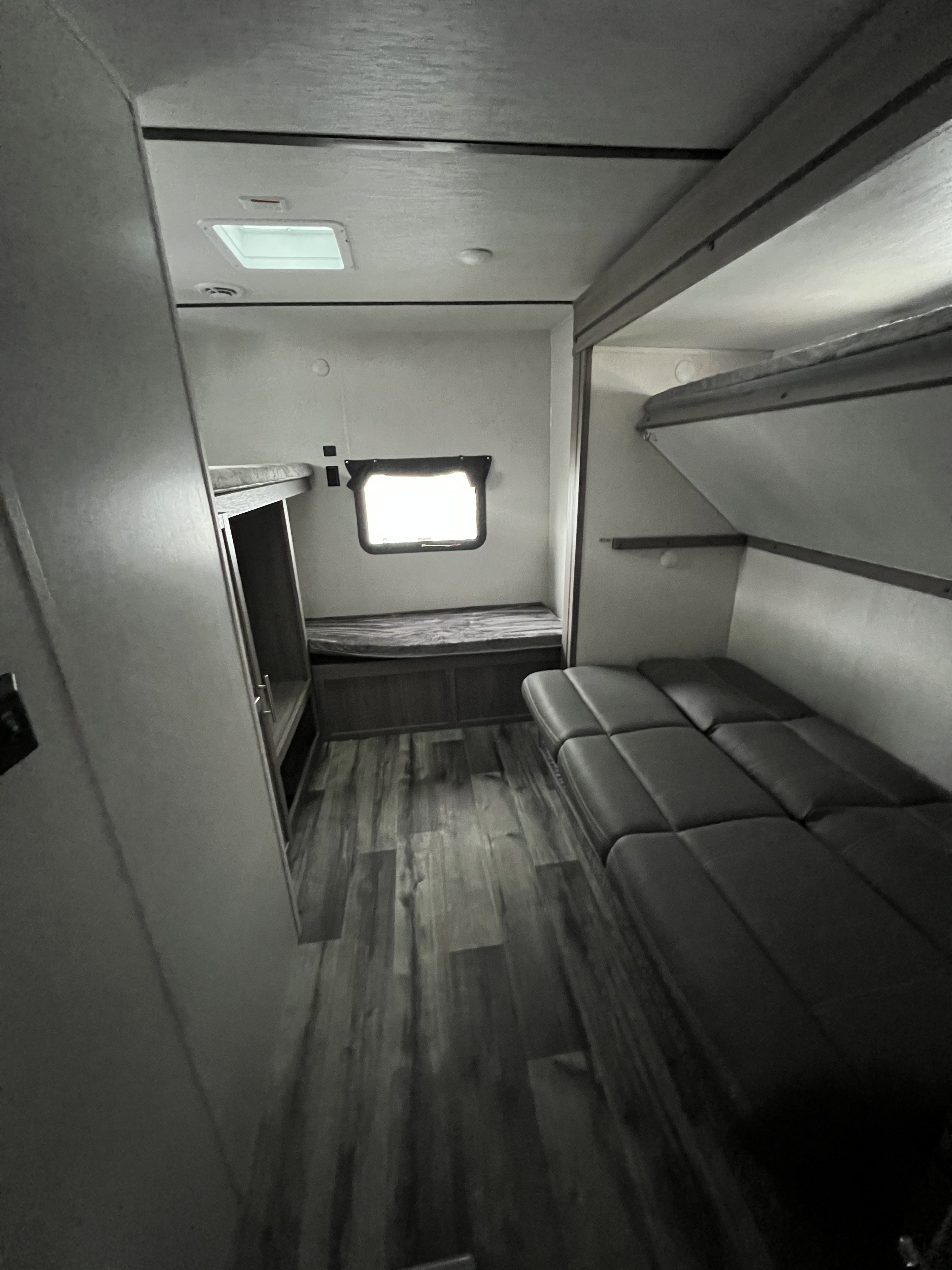 RV rental interior: cozy bunk beds, sofa, & wood-look floor. Ideal for family adventures & comfortable travel.. Crossroads RV Volante 2022