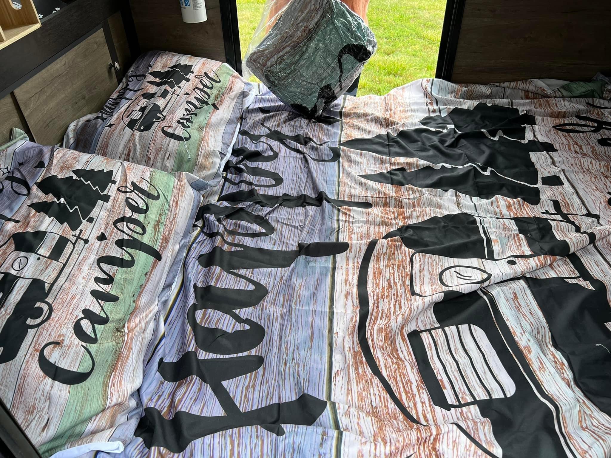 Rustic wood grain & camper-themed bedding in an RV rental. Perfect for your next camping adventure!. Braxton Creek Free Solo 2022