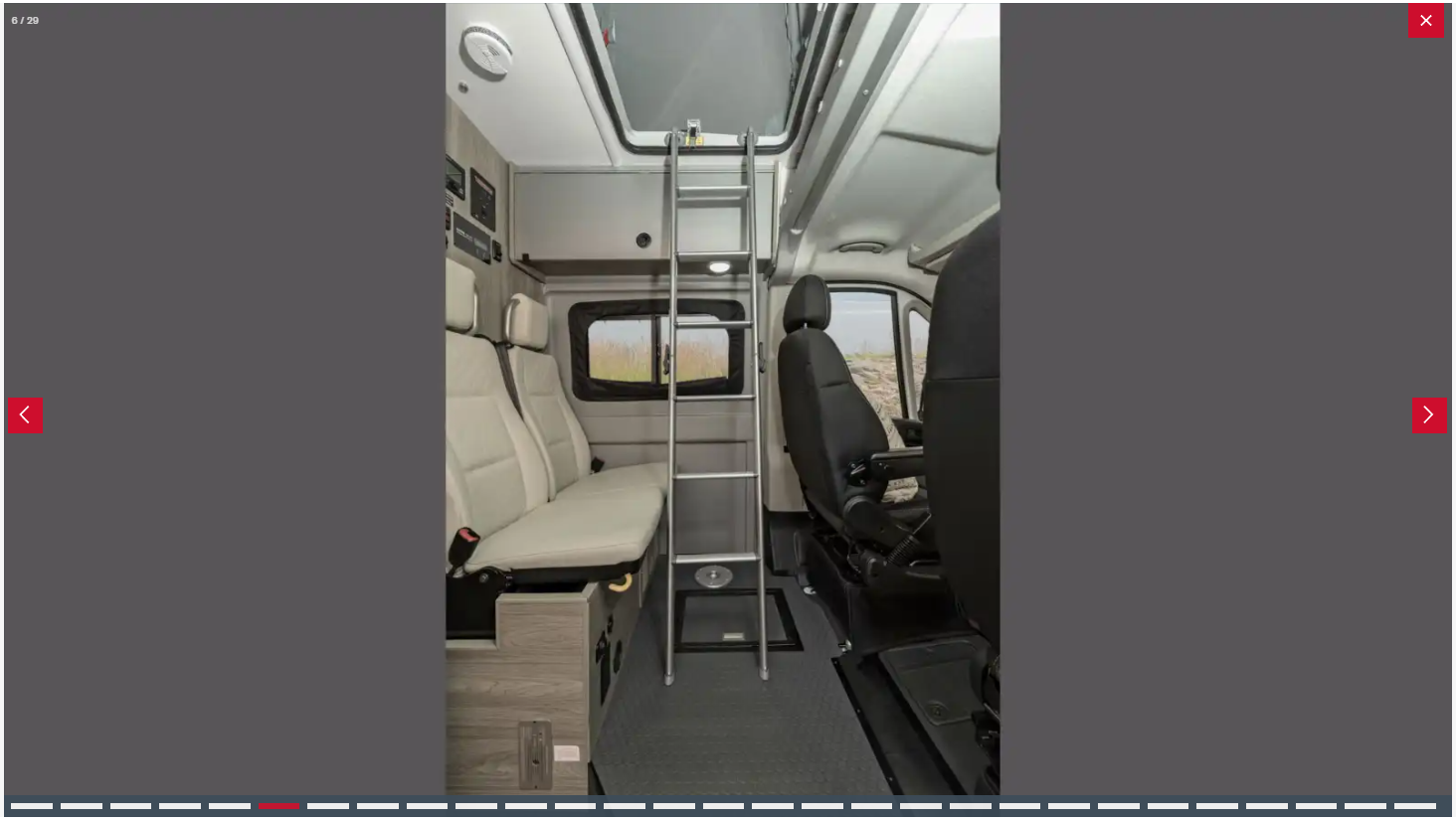 RV rental camper van interior. Features passenger seating, ladder to a loft bed, and front cockpit.. Winnebago Solis 59P 2023