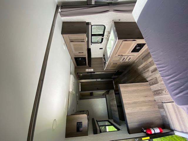 Explore this RV rental's interior: a kitchen, bedroom, and spacious toy hauler area with a fire extinguisher.. Gulf Stream Trailmaster 2022
