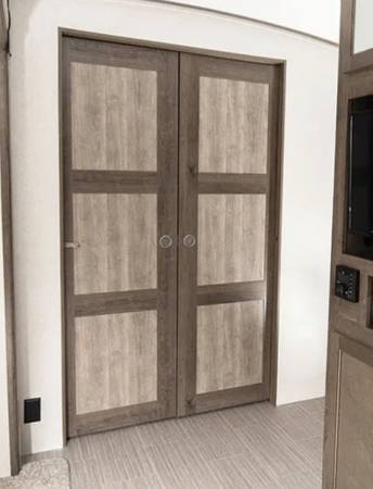Sliding doors separate the master bedroom from the rest of the trailer.. Keystone RV Passport GT 2021