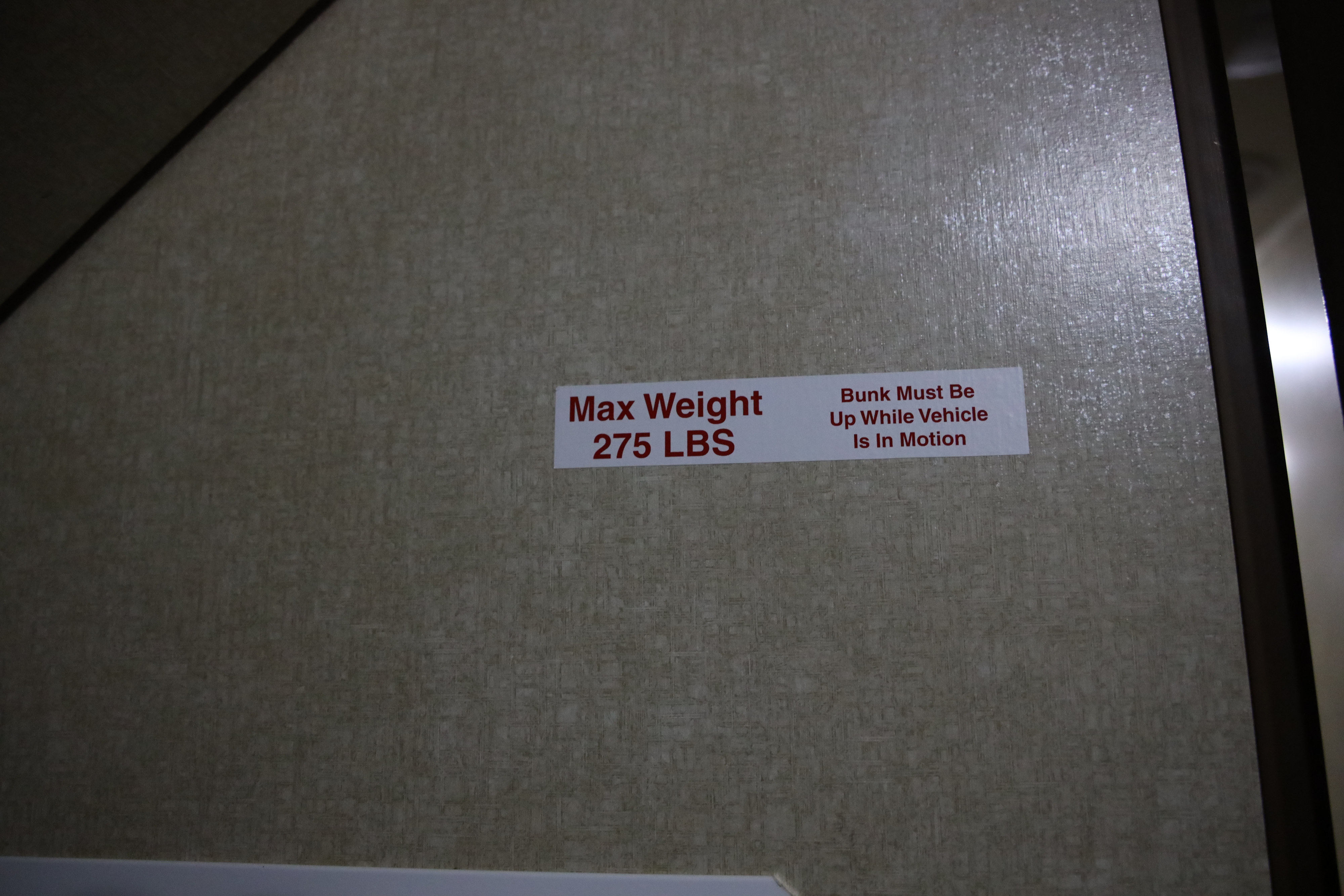 RV rental safety sticker on a textured wall: 275 LBS max bunk weight, up during motion.. Cruiser RV Radiance 2015