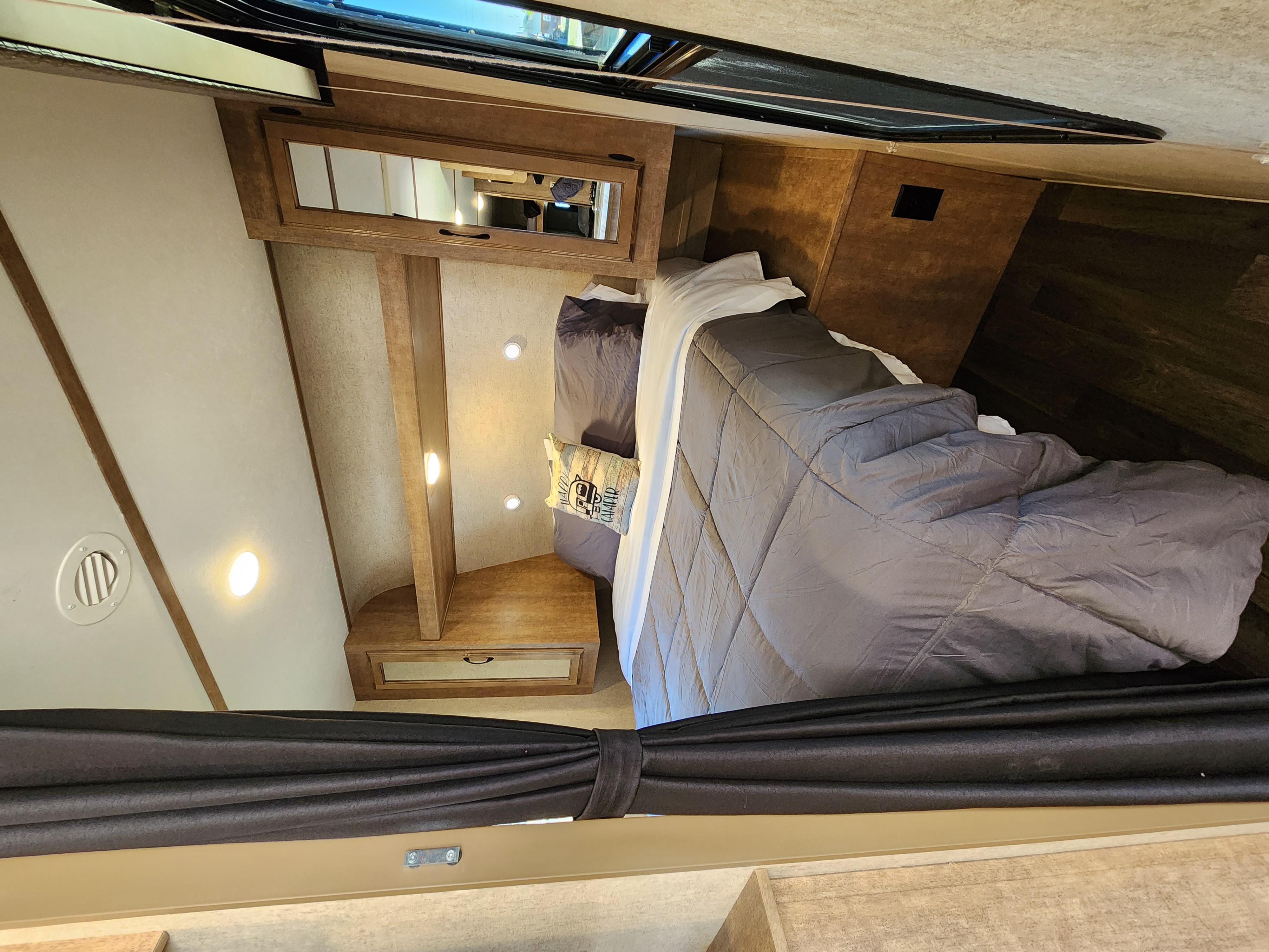 RV rental: a cozy bedroom with bed, gray comforter, wood cabinets, skylight, and privacy curtains drawn.. Starcraft Launch Outfitter 2018
