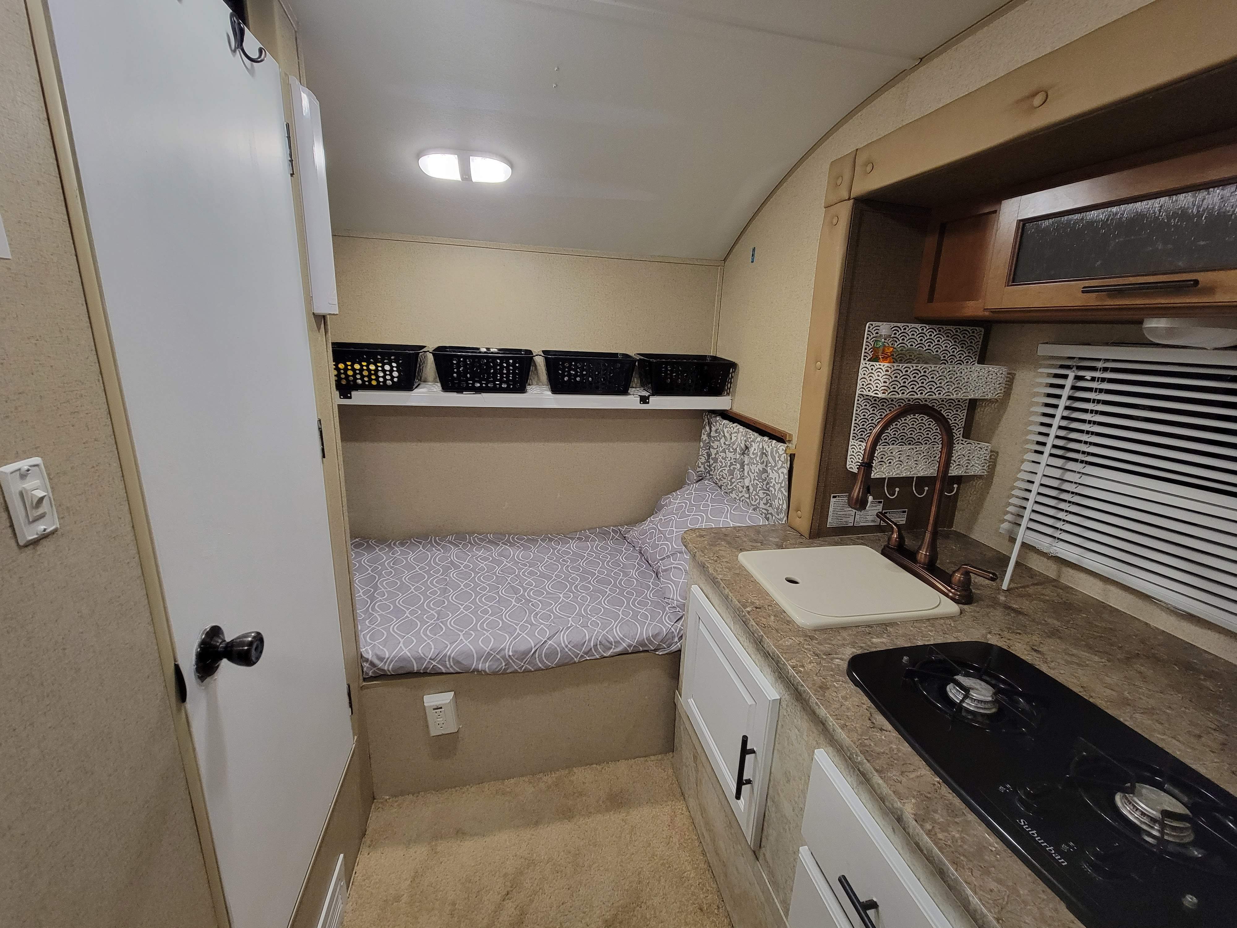 RV rental features: compact kitchen with stovetop & sink, comfy bed, storage baskets, and lighting.. R-Pod R-Pod Trailer 2015