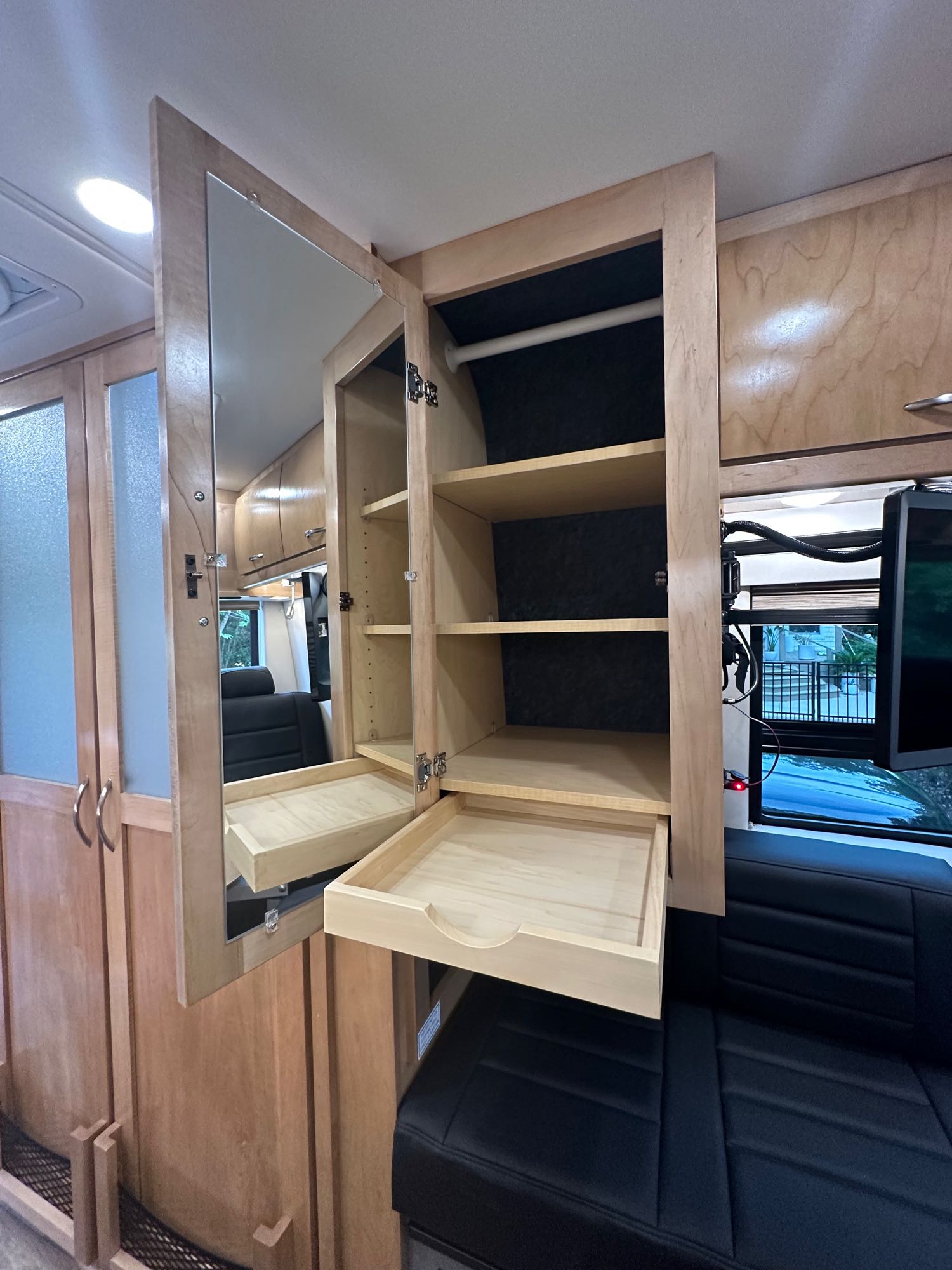 RV rental with a mirrored cabinet, shelves, pull-out drawer & TV, showcasing smart interior storage.. Coachmen Other 2022