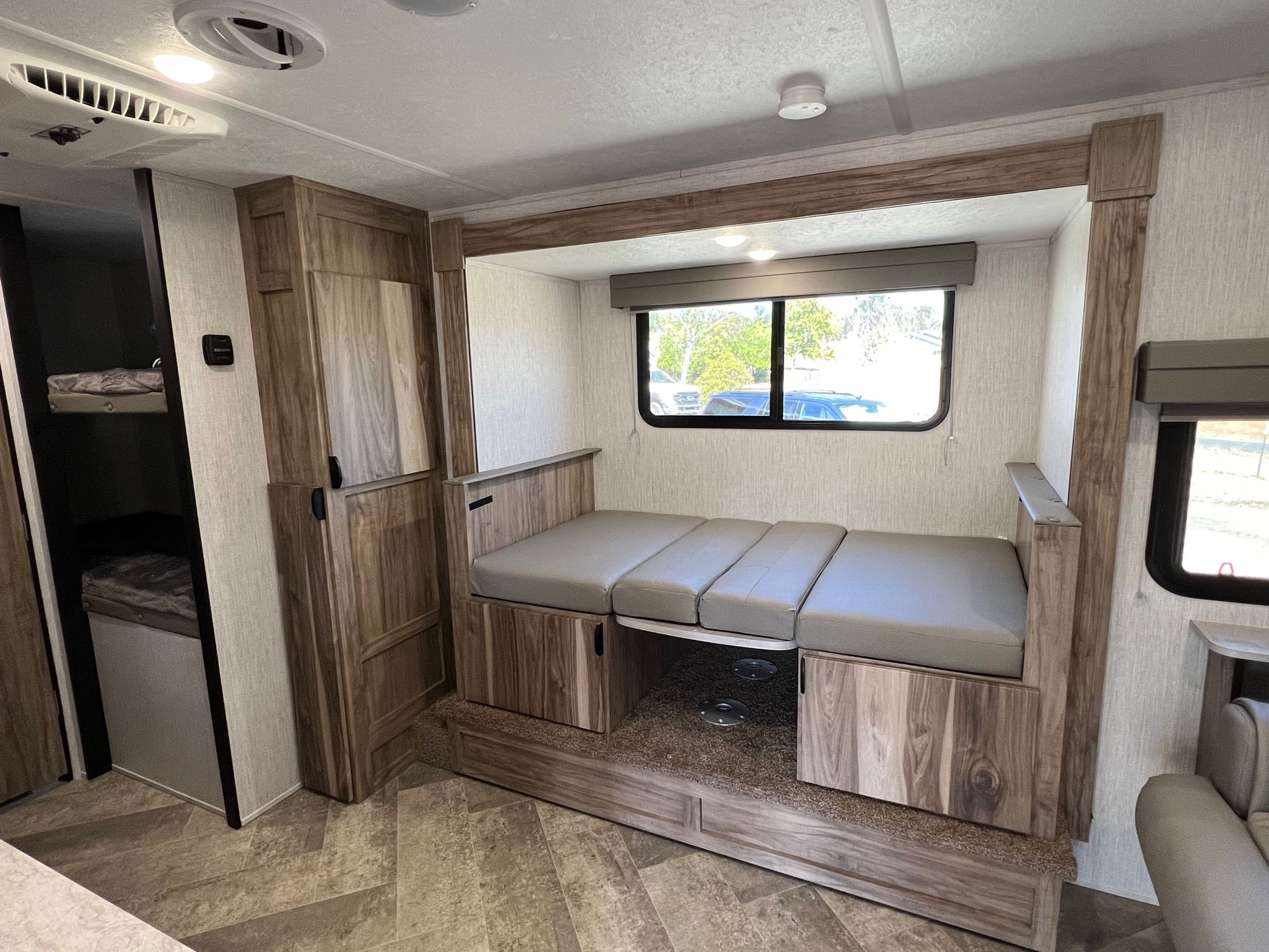 Experience an RV rental: view of a dinette with gray cushions, a convertible bed base, and a bunk area.. Palomino Palomini 2022