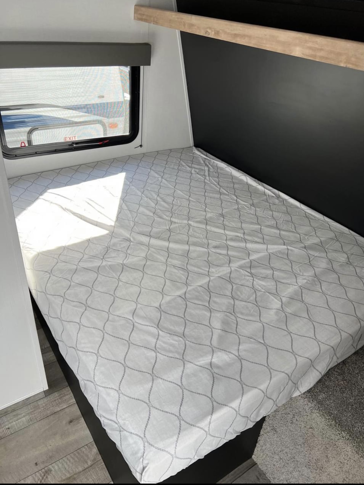 Comfortable RV rental bedroom featuring a modern design, large window, and patterned bed cover. Perfect for travel.. Keystone Springdale 1750 2022