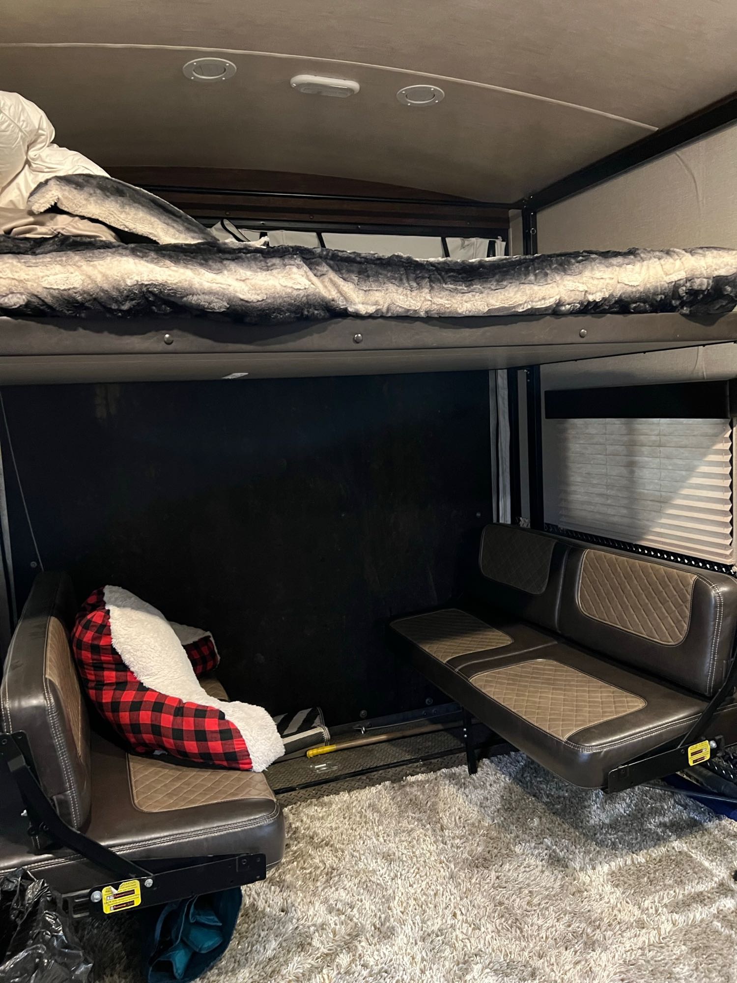 RV rental interior: Cozy bunk bed over versatile seating in a toy hauler. Plush carpet and blinds.. Heartland Torque 2017