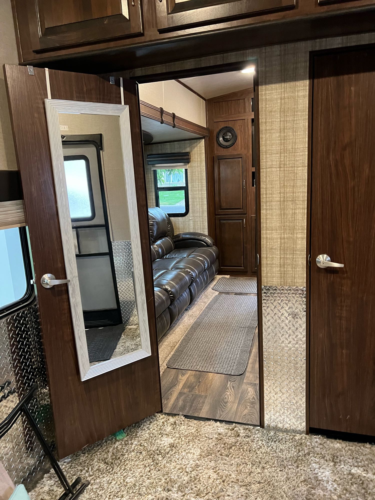 Spacious RV rental interior with a comfy leather couch, wood cabinets, and diamond plate accents, offering a cozy living area.. Heartland Torque 2017
