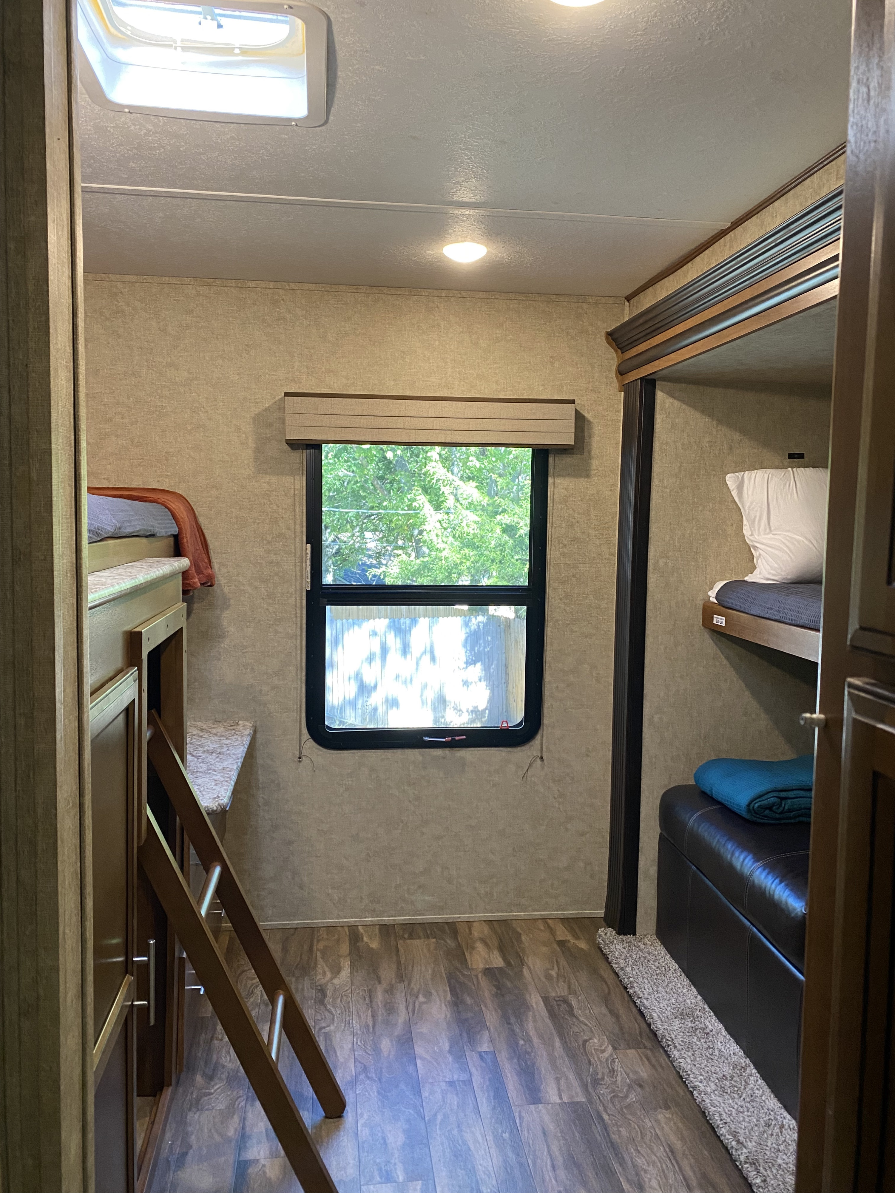 Spacious RV rental interior with comfortable bunk beds, a ladder, window, and seating. Perfect for family trips.. Other Other 2017