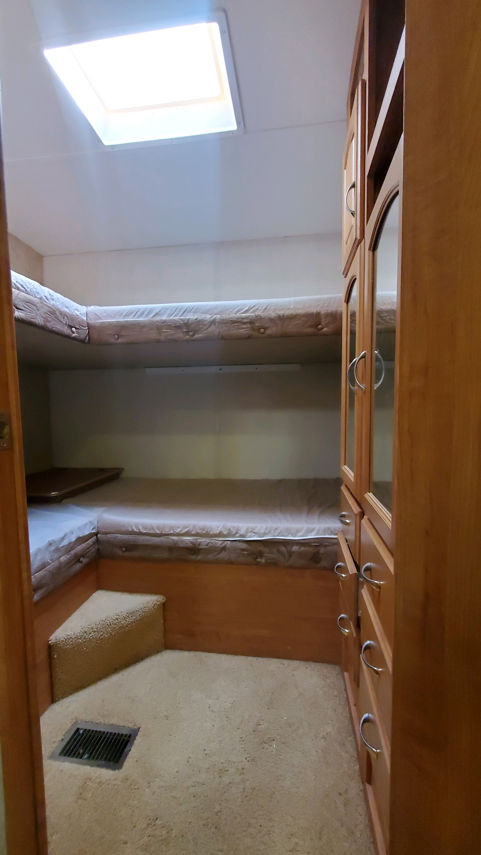 RV rental interior: Cozy bunk beds with storage cabinets and a skylight for natural light.. Forest River Wildcat 2009