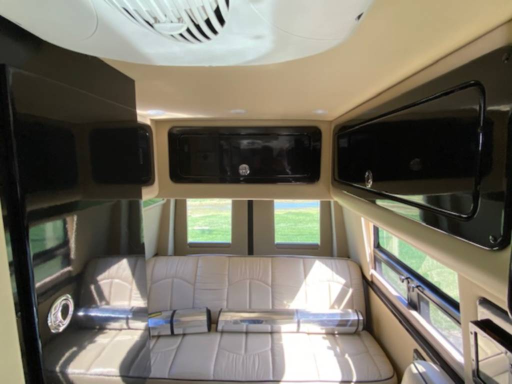 Cozy RV rental interior showing a comfortable seating area, overhead storage, and scenic windows for your next adventure.. Mercedes Sprinter 2015