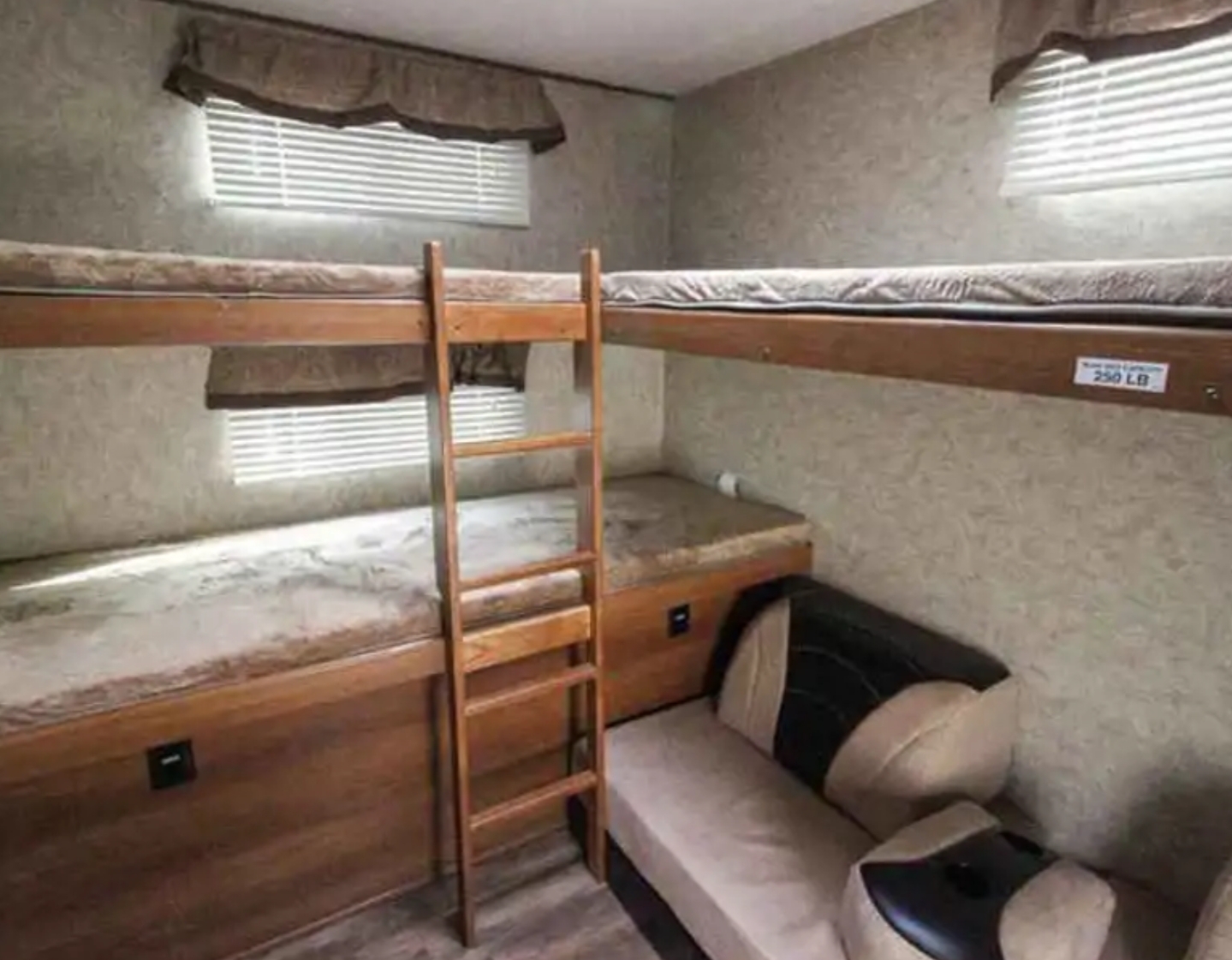 This RV rental offers a compact sleeping area with built-in bunk beds, a ladder, and a cozy seating couch.. Prime Time Tracer Air 285 2018