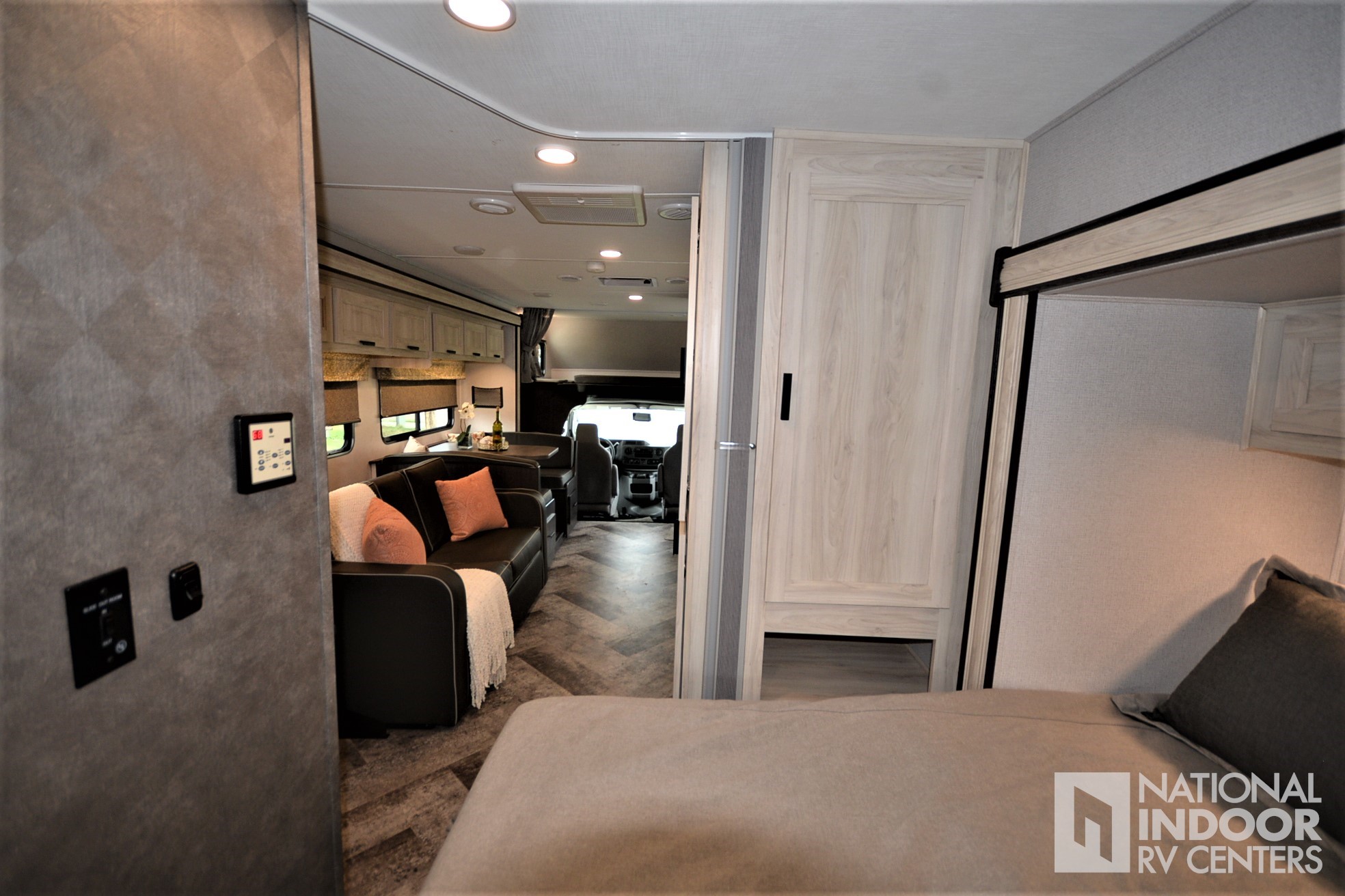Inside a stylish RV rental: cozy bedroom view to living area, dining nook & cockpit. Modern camper design.. Forester LE 2021