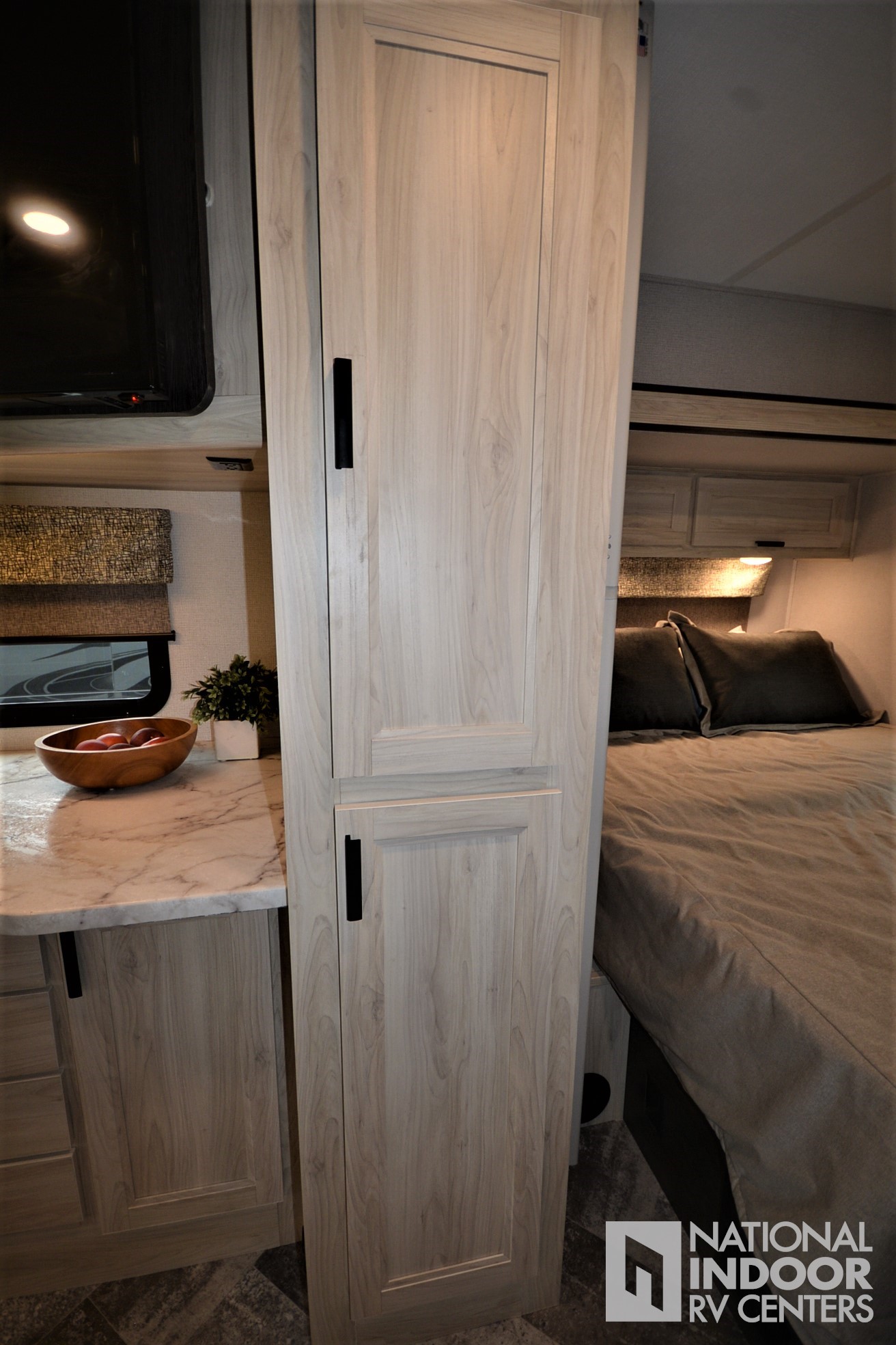 Light wood RV interior with a tall pantry, compact kitchen counter, and cozy bedroom, ideal for your rv rental experience.. Forester LE 2021