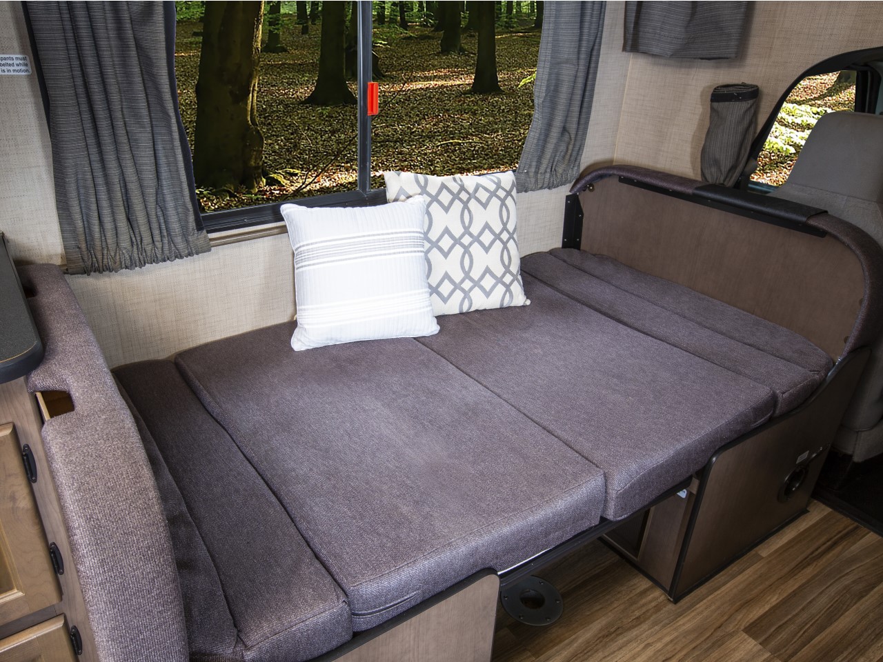 RV rental interior: Comfortable convertible sofa/bed with pillows & forest view. Perfect for travel & relaxation.. Thor Majestic 2018