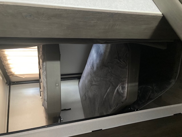 RV rental interior: A compact sleeping area featuring a folded bunk bed on the right and another bunk with a bright window.. Forest River Salem 2020